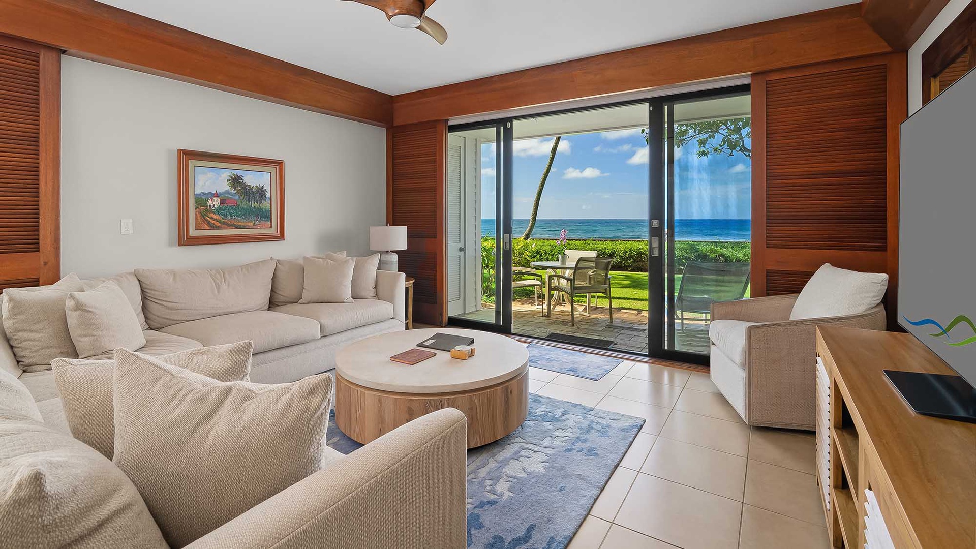 Relax in your bright, airy living space with stunning ocean views just steps away. Sink into plush seating as tropical breezes drift through open glass doors. Your private slice of paradise awaits beyond the lush lawn.