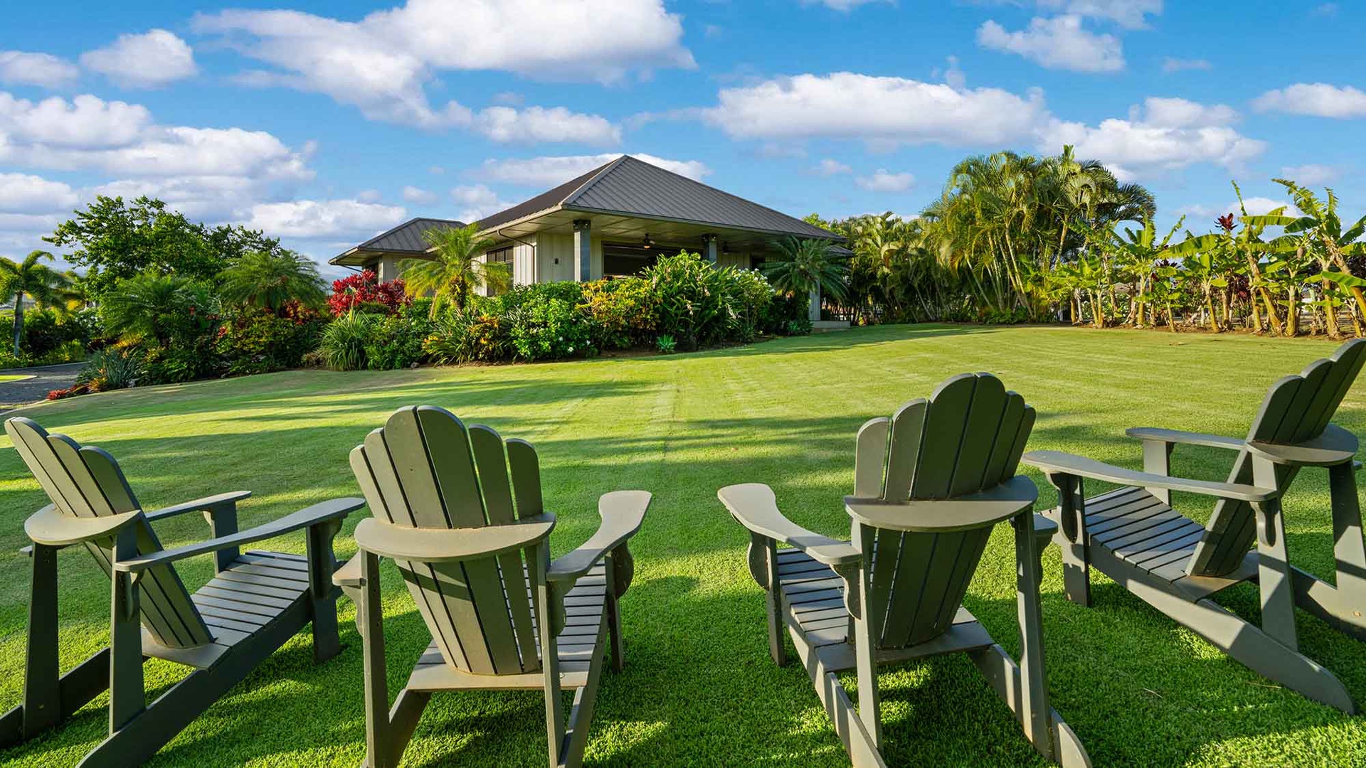 A private tropical estate surrounded by lush gardens, manicured lawns, and swaying palms under a bright, sunny sky—your serene island escape awaits in this peaceful setting.