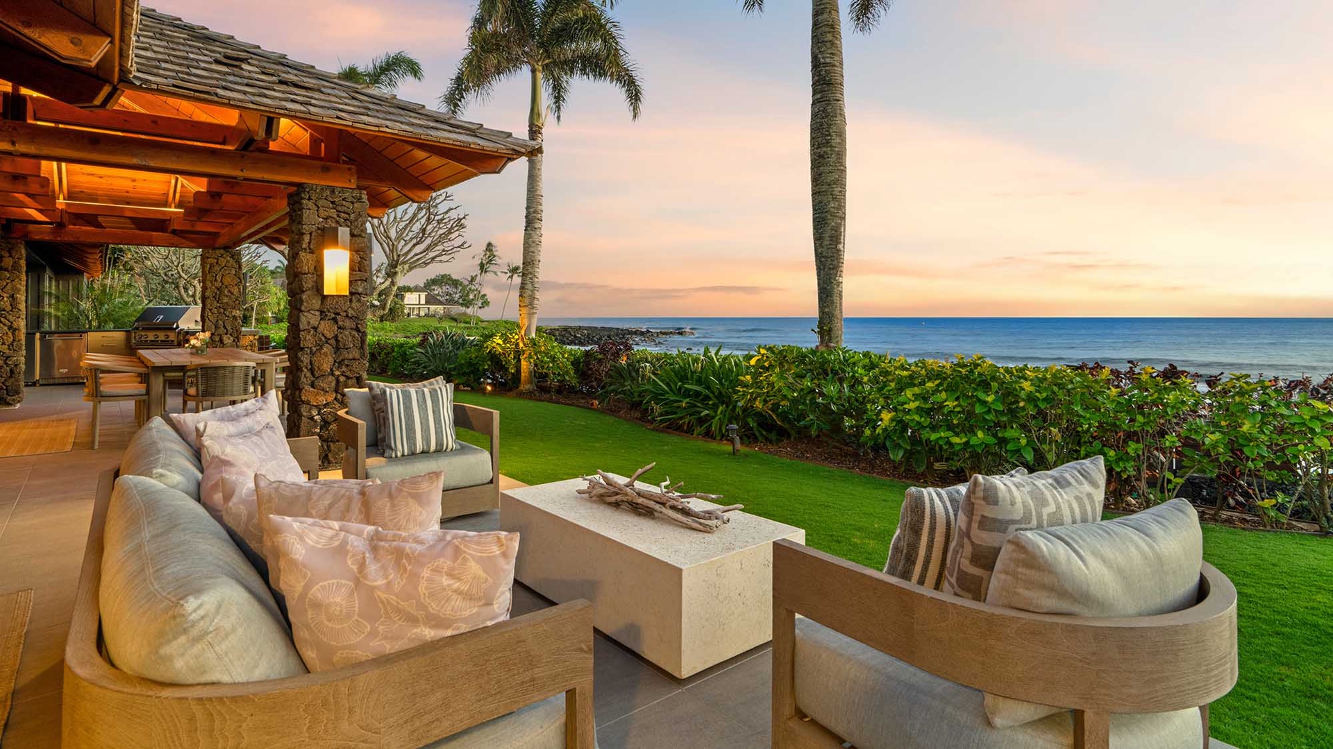 Oceanfront terrace offering stunning sea views with tropical landscaping and swaying palms in a resort-style setting.