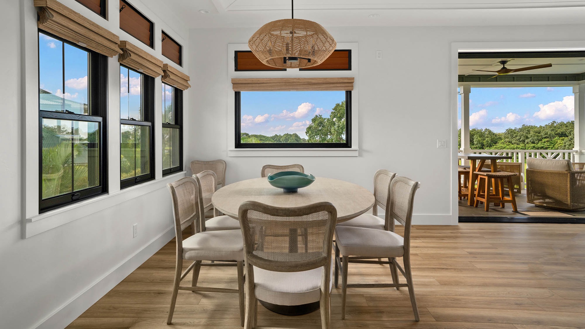 Gather around your beautiful dining table surrounded by windows showcasing peaceful countryside views through every frame.