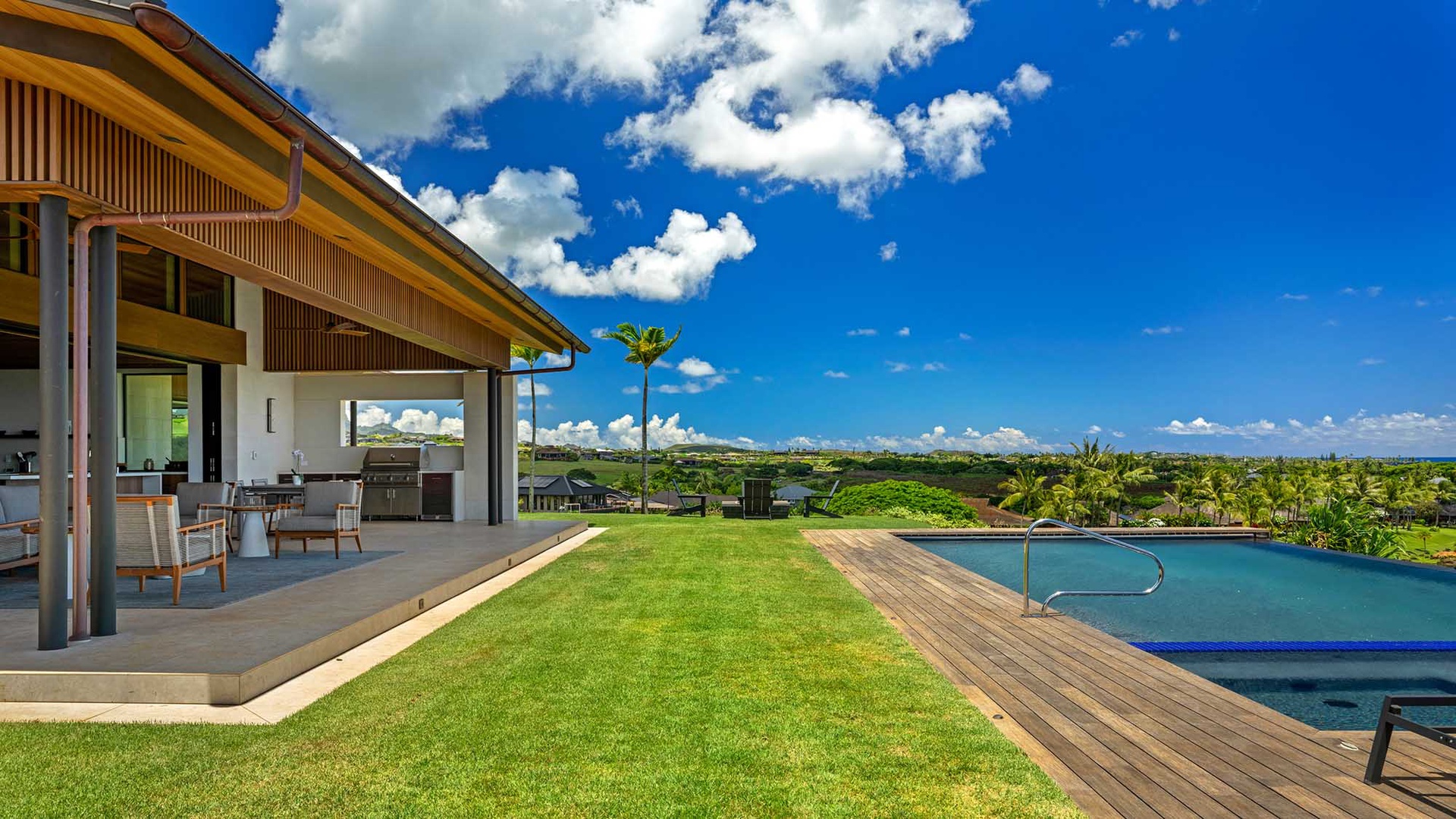 This stunning covered patio opens to a pristine lawn and infinity pool overlooking lush tropical greenery. Picture yourself soaking in the expansive sky views from your private outdoor oasis.