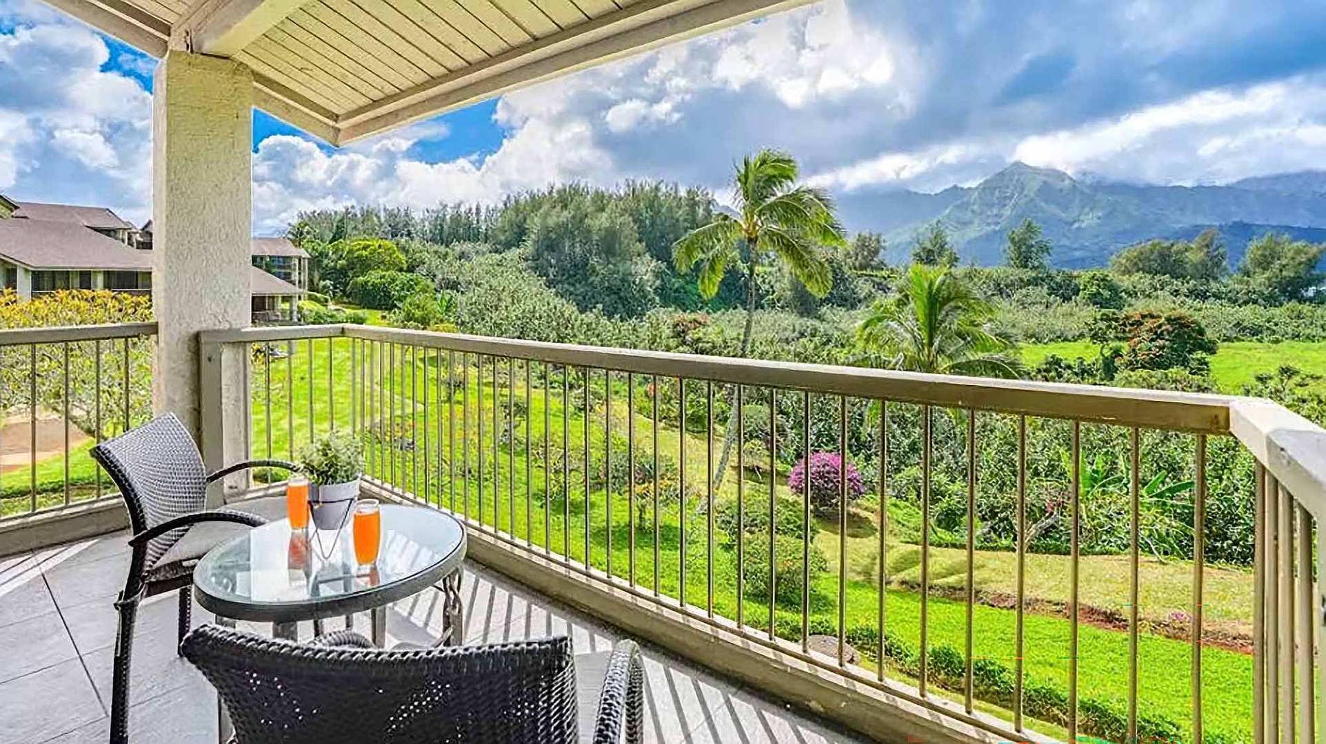 Enjoy your morning coffee on this peaceful covered lanai with sweeping views of lush tropical gardens and majestic mountain peaks in the distance.