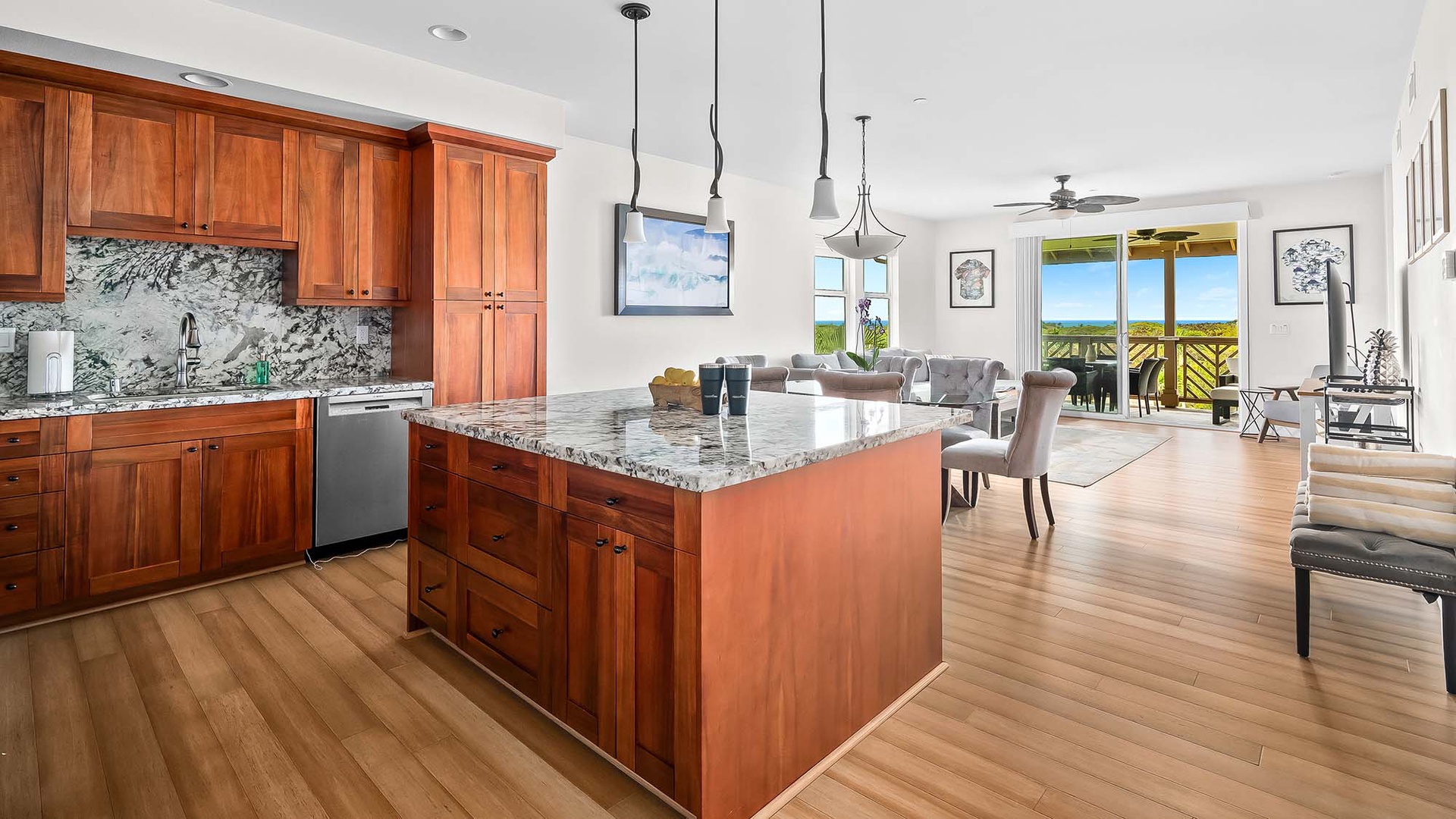 Picture yourself cooking in this bright, open kitchen with gleaming granite counters and warm wood cabinets, then stepping out to your balcony to soak in stunning views of lush greenery and ocean beyond.