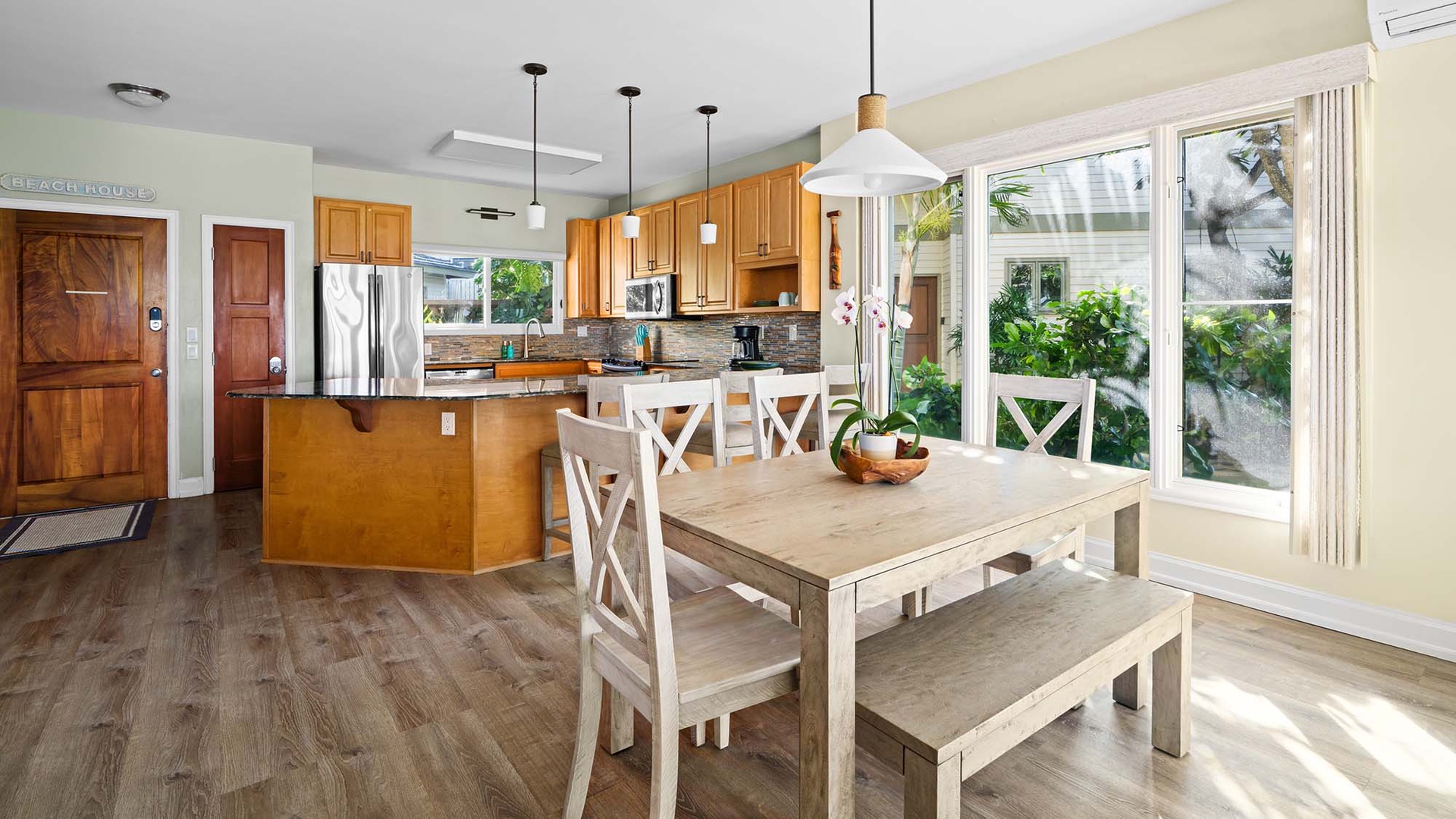 Enjoy cooking and dining in this bright, open space with a fully equipped kitchen and sunny dining nook overlooking lush greenery.