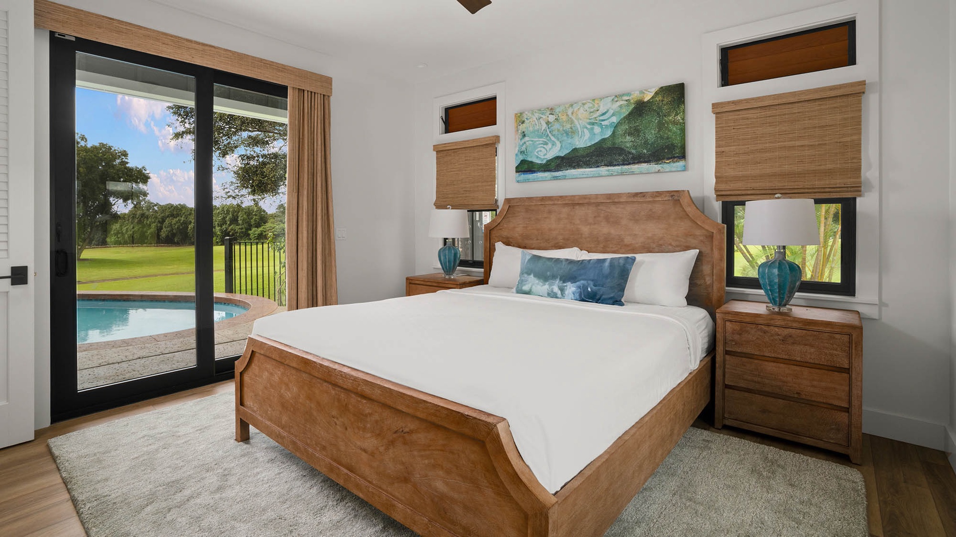 Wake up to pool and garden views from your elegant bedroom, where warm wood tones and crisp linens create your perfect retreat.