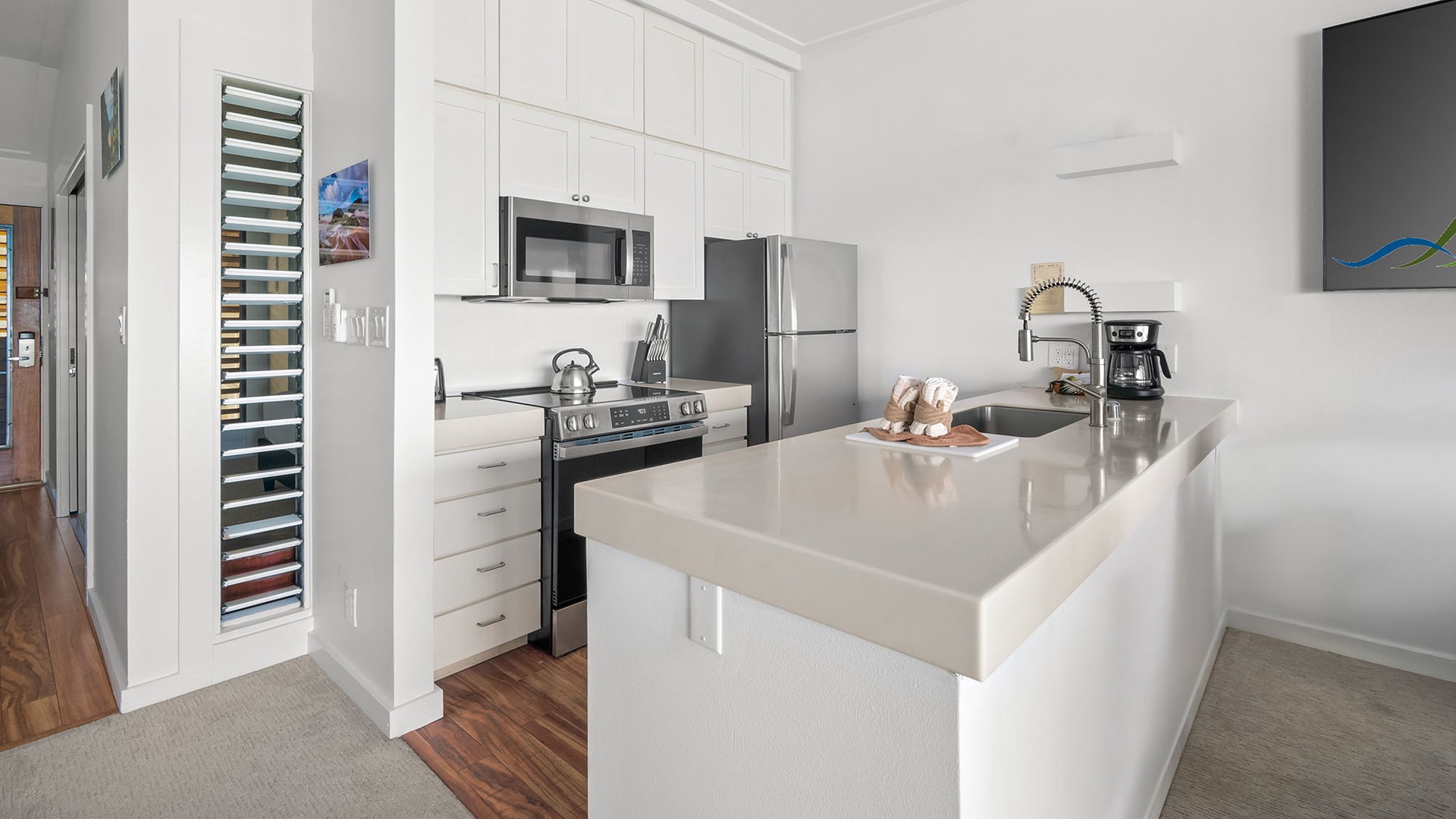 Step into your sleek, modern kitchen featuring stainless steel appliances, gleaming quartz countertops, and ample cabinet space for preparing delicious meals during your stay.
