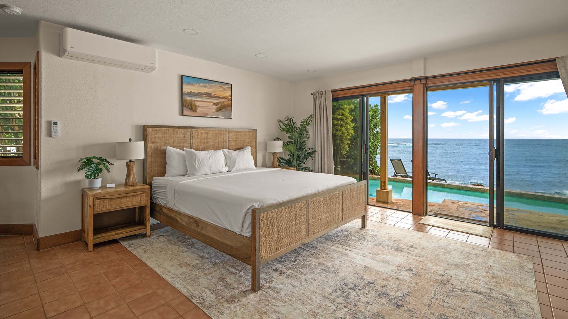 Wake to breathtaking ocean views from your comfortable woven rattan bed, where tropical breezes flow through sliding doors.