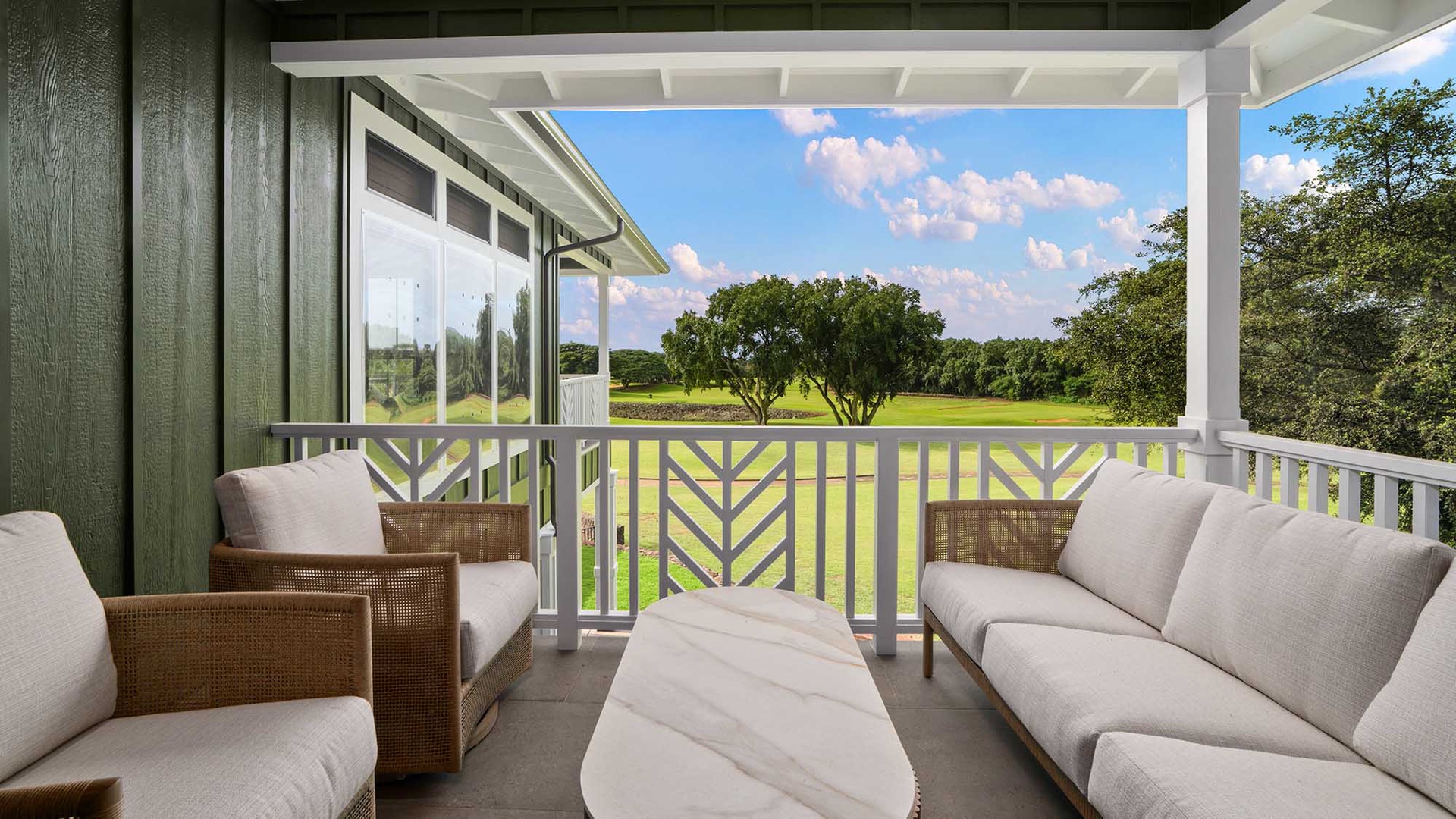 Your private covered terrace beckons with plush seating and sweeping views of lush green landscape, perfect for morning coffee or sunset drinks.