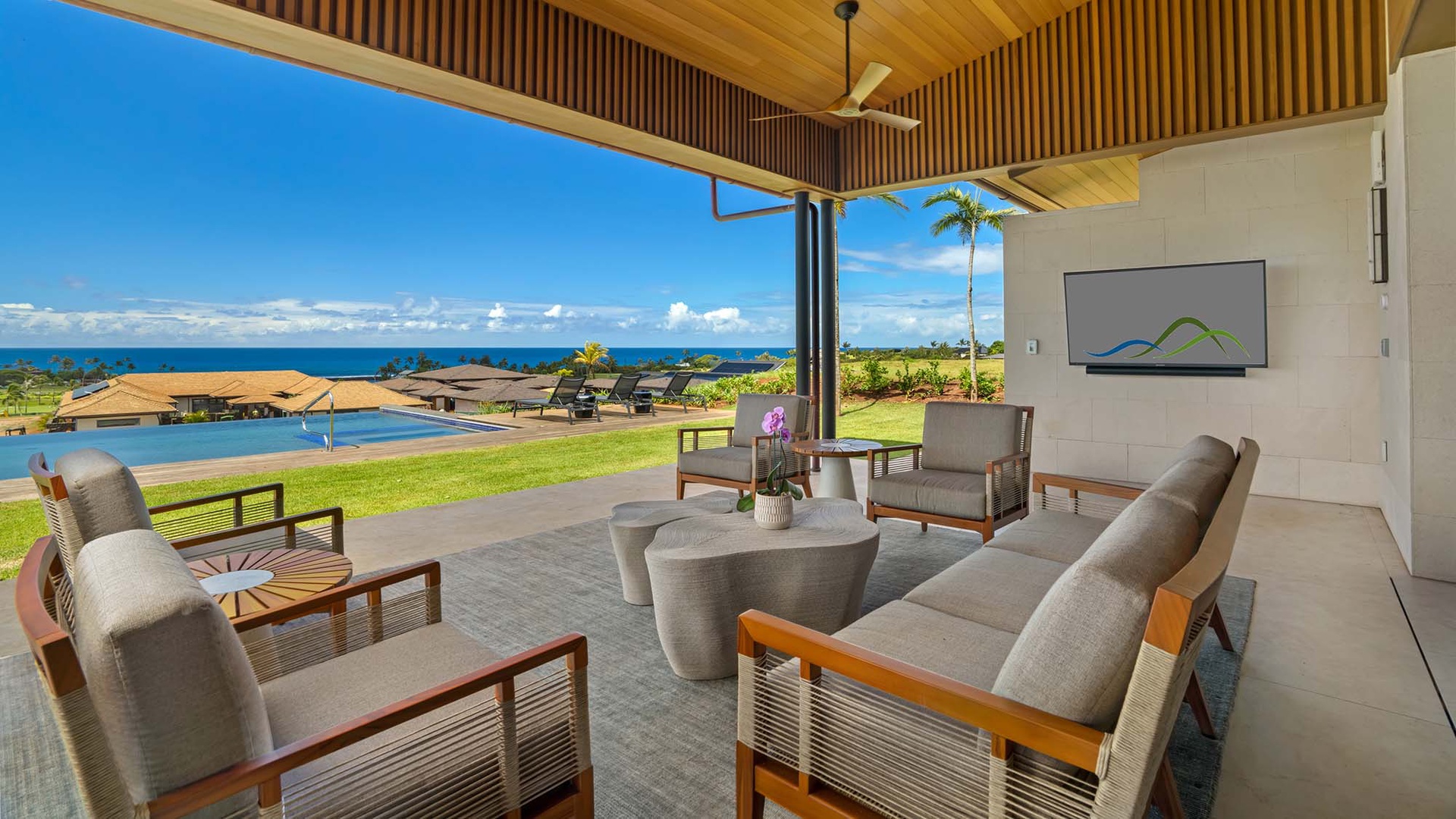 Sink into plush seating under rich wood ceilings as the open pavilion frames your sweeping ocean view, blending indoor comfort with Hawaii's endless blue horizon.