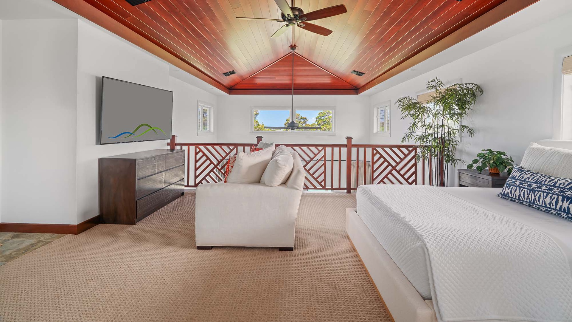 Your loft retreat features a stunning vaulted wood ceiling, cozy seating, and a peaceful bed overlooking lush greenery—perfect for unwinding after a day of adventure.