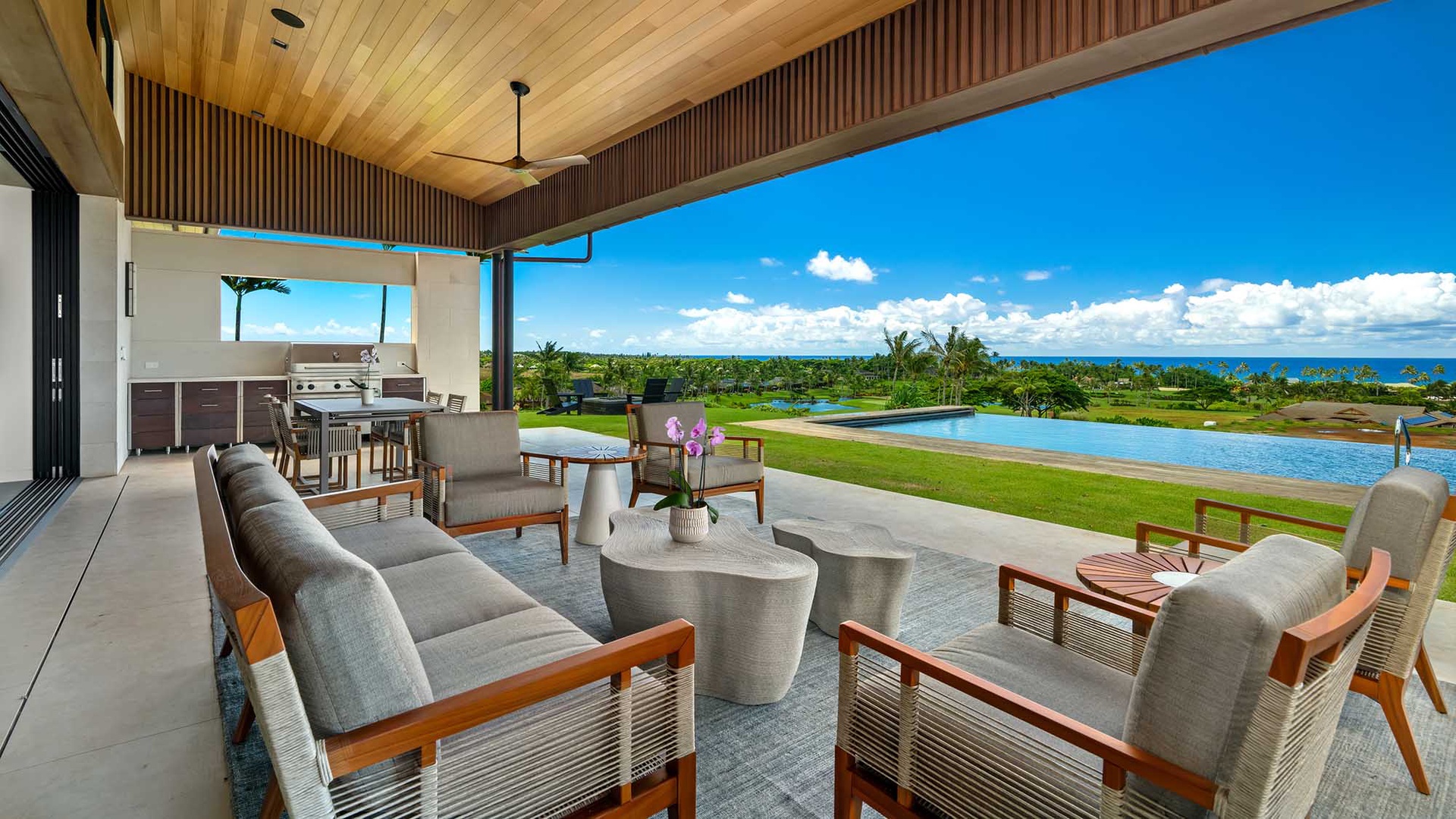 An expansive covered terrace with comfortable seating, BBQ area, and sweeping ocean and pool views stretches before you—your perfect spot for morning coffee or sunset cocktails.