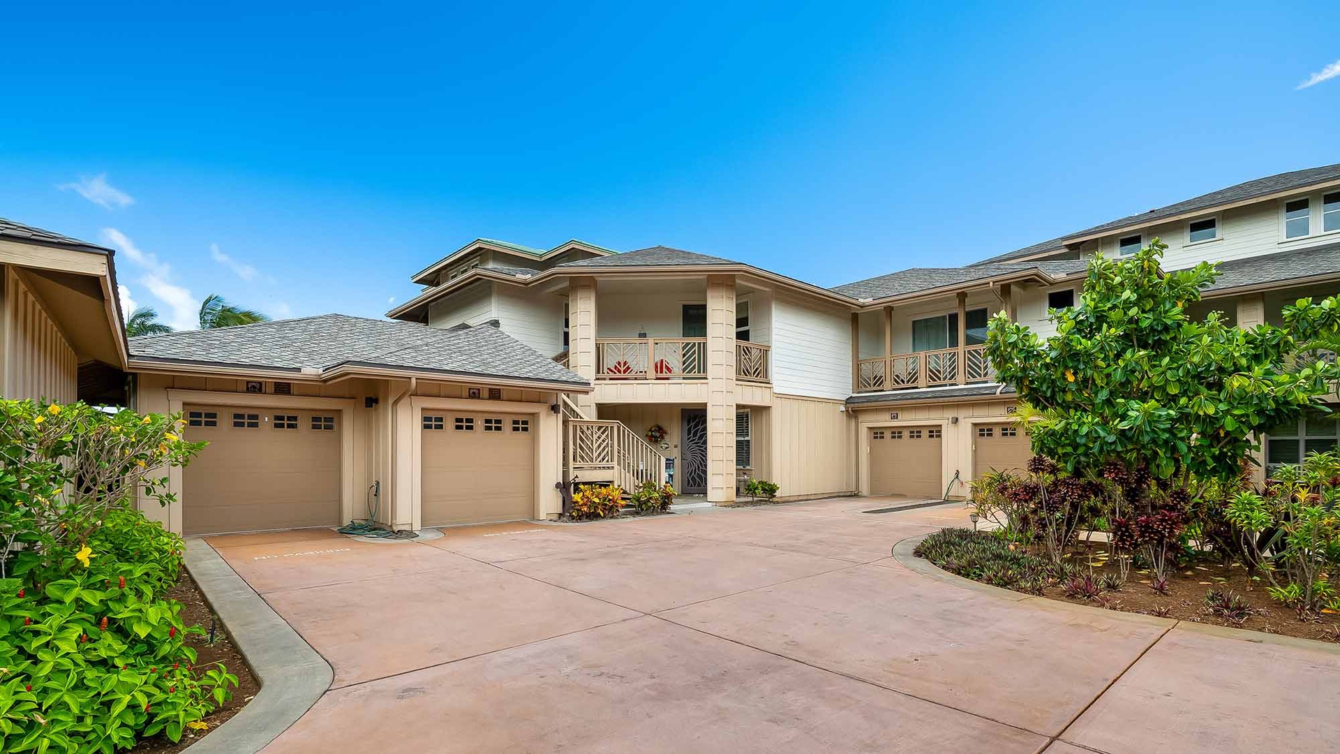 The property features classic Hawaiian architecture with multiple garage spaces, well-maintained landscaping, and a spacious driveway, situated within a peaceful residential setting.
