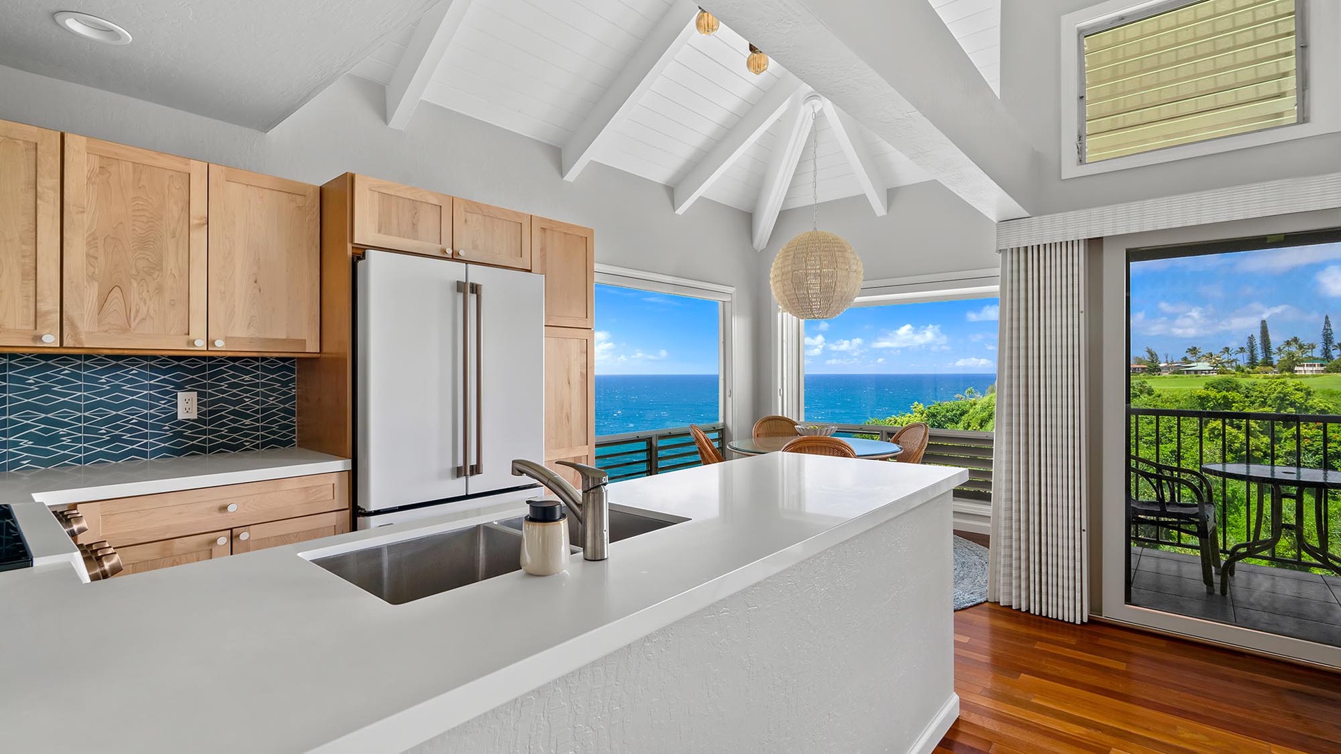 Your gourmet kitchen opens to stunning ocean views, where vaulted ceilings and breezy balcony access make every moment feel like paradise.