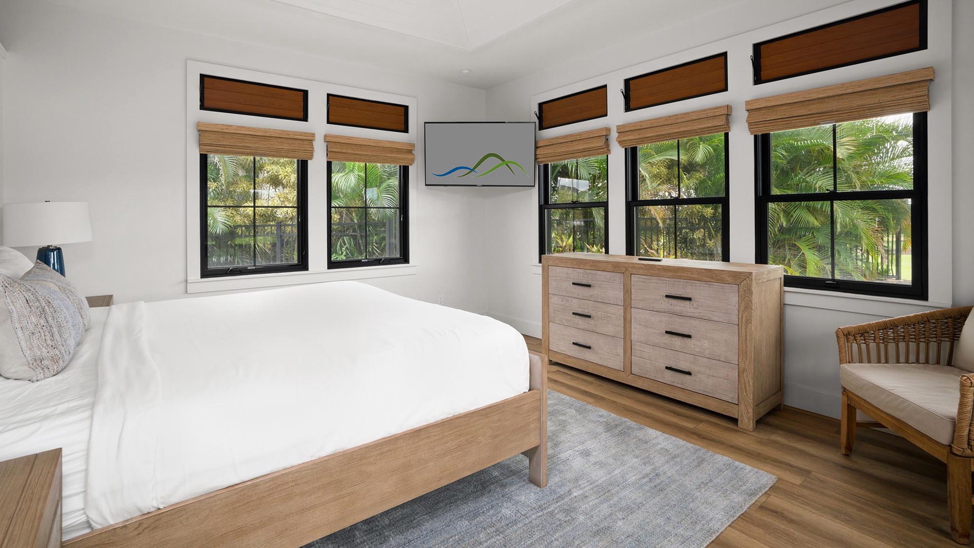 Wake up in your serene bedroom where tropical palms frame the windows and crisp white linens await your peaceful night's rest.