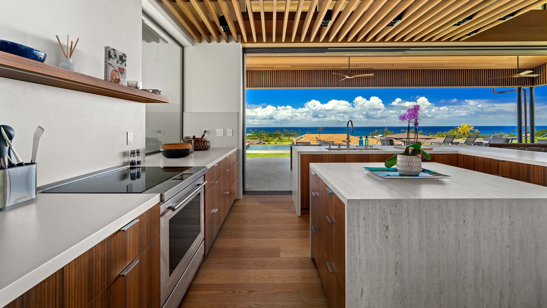 Step into this stunning kitchen where modern design meets breathtaking island beauty—floor-to-ceiling windows frame your endless ocean vistas while you create memorable meals in luxury.