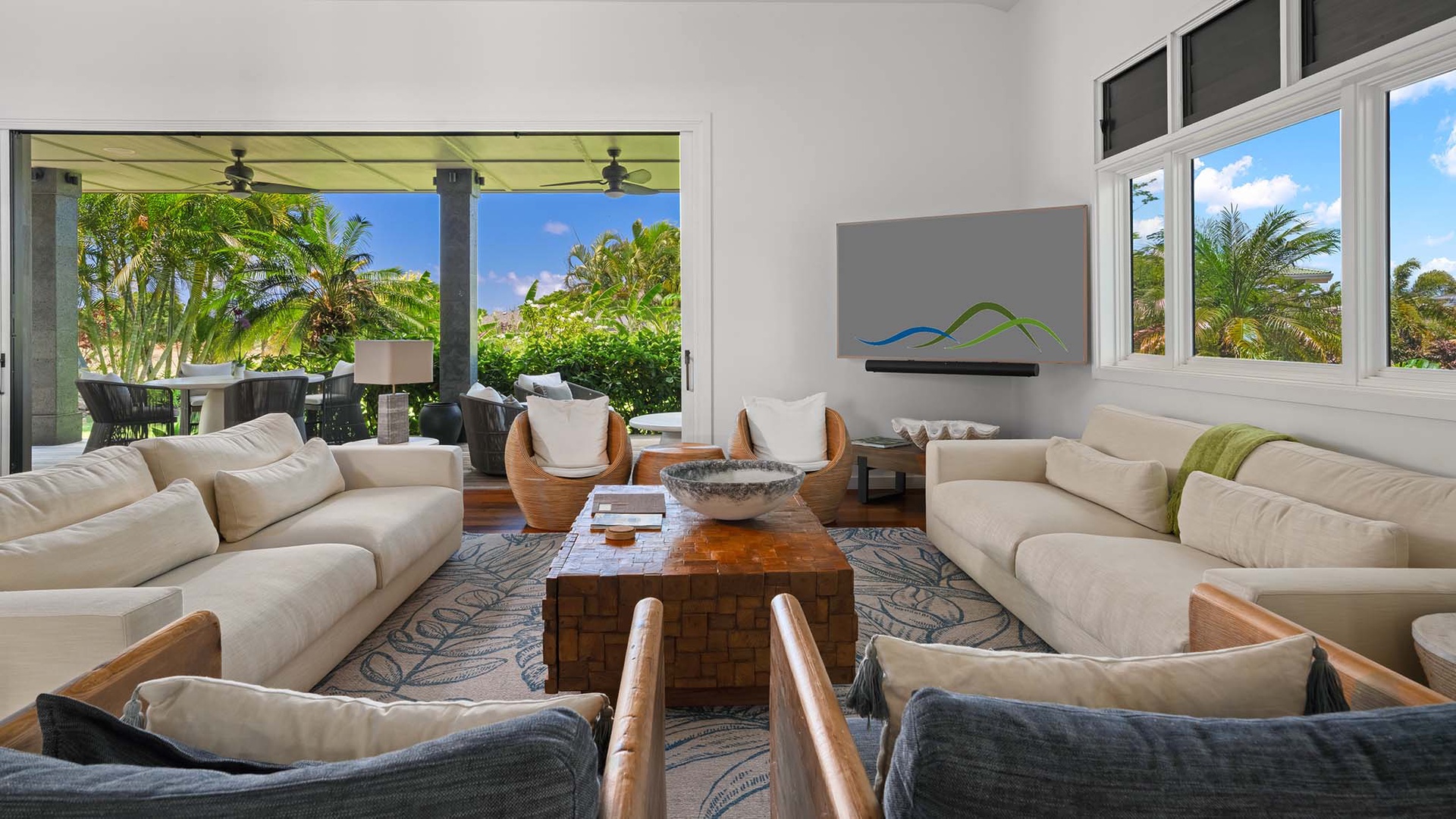 Sink into plush sofas in your sun-drenched living room, where floor-to-ceiling doors frame lush tropical gardens and your private outdoor oasis awaits just steps away.