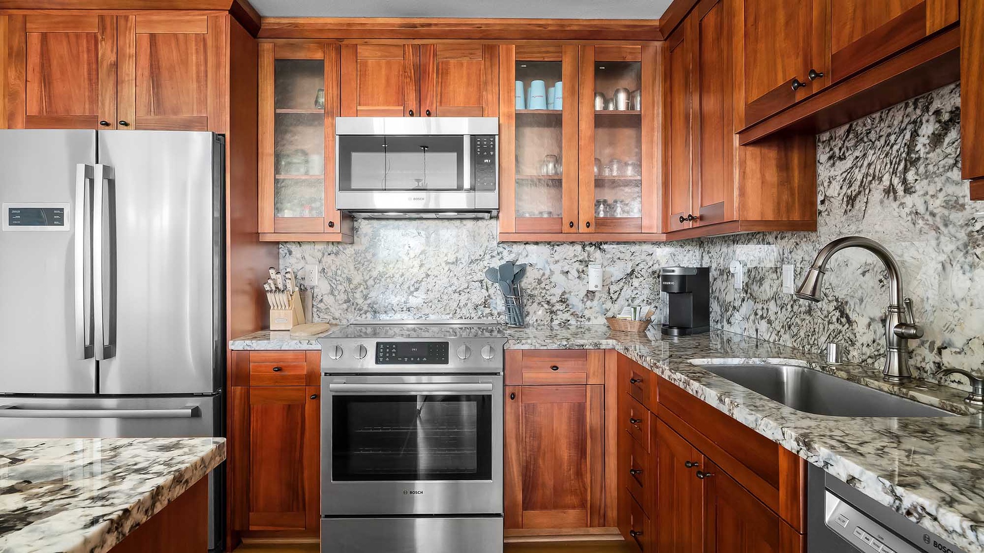 Your fully equipped kitchen awaits, featuring rich wood cabinetry, granite countertops, and everything you need to prepare a feast or brew your morning coffee.