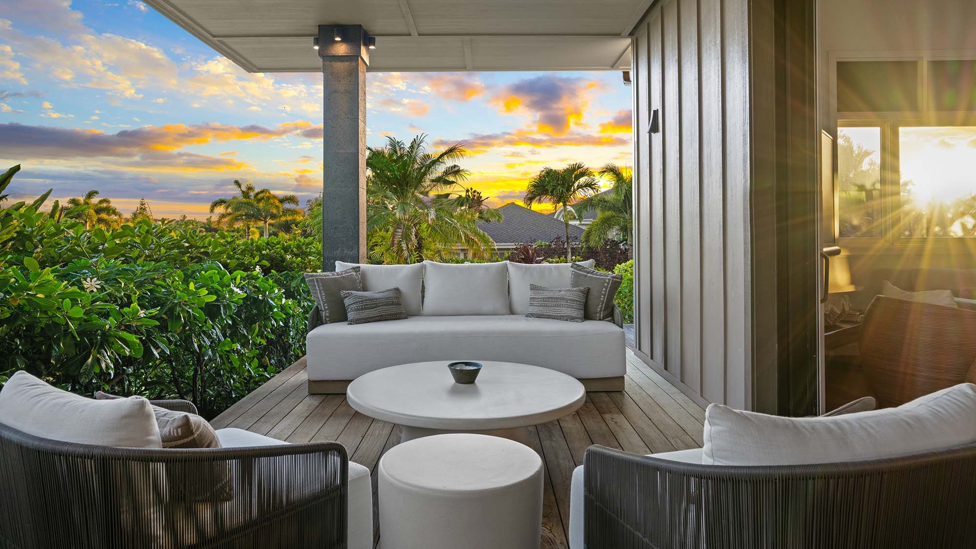This covered outdoor seating area surrounds you with lush tropical greenery, creating a peaceful retreat where you can watch sunset colors paint the sky.