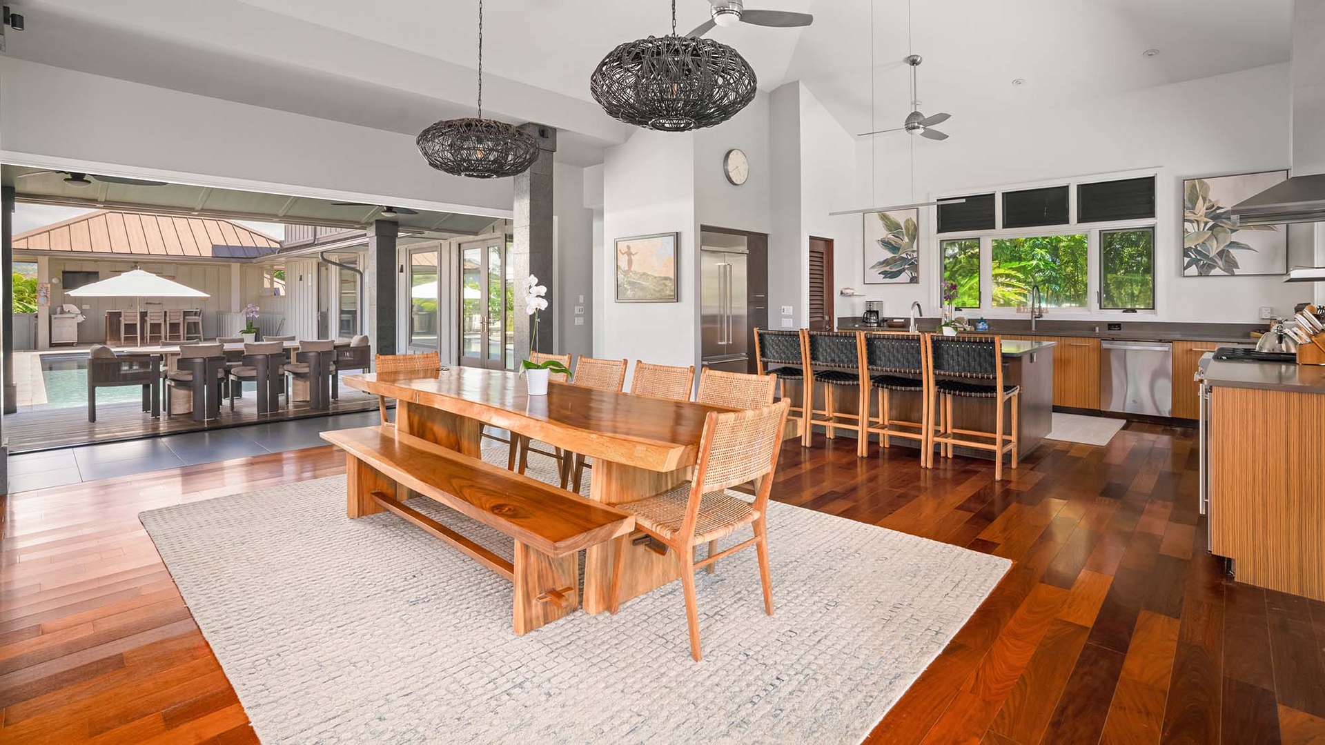 Gather around rich wood tables bathed in natural light, where your group can share meals in an open, airy space that flows seamlessly from kitchen to outdoor pool area.