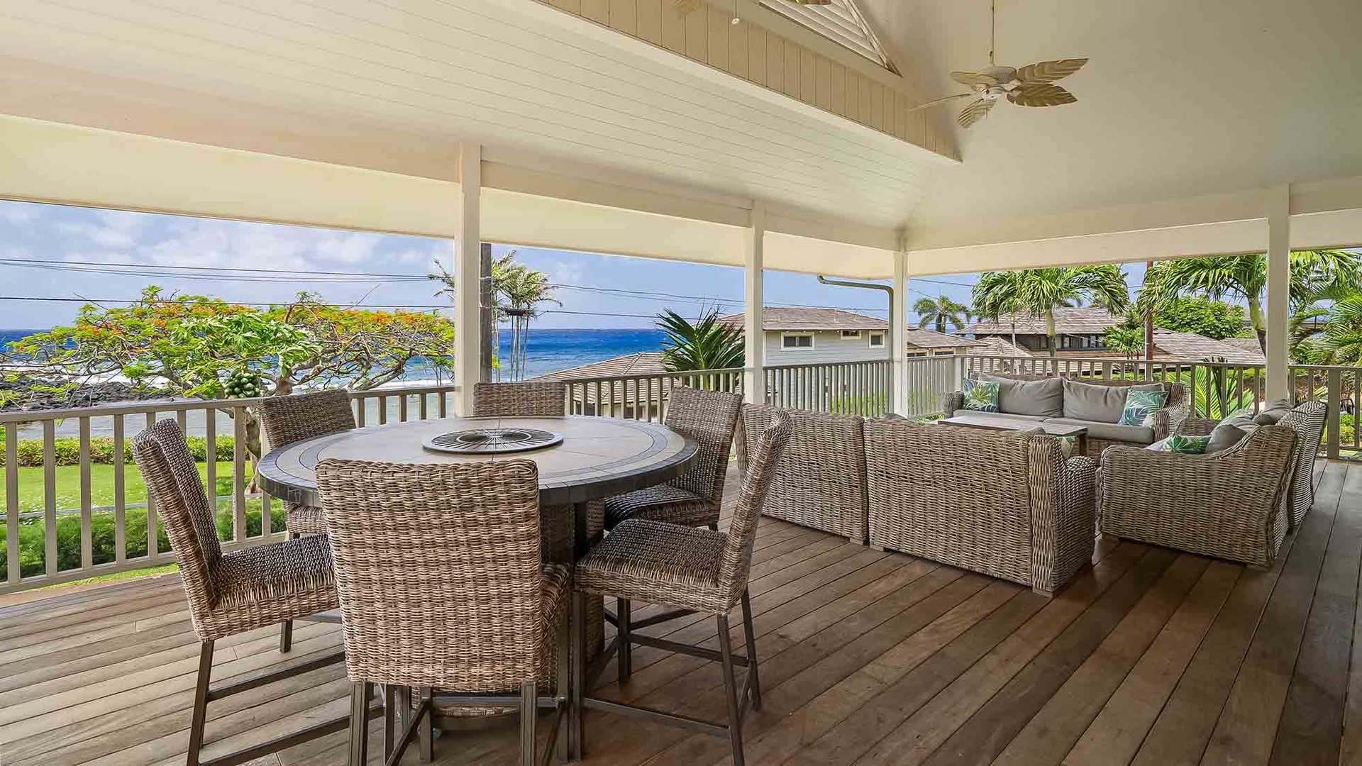 Your covered lanai offers sweeping ocean views from comfortable wicker seating and an inviting dining table—perfect for savoring meals and island breezes in total relaxation.