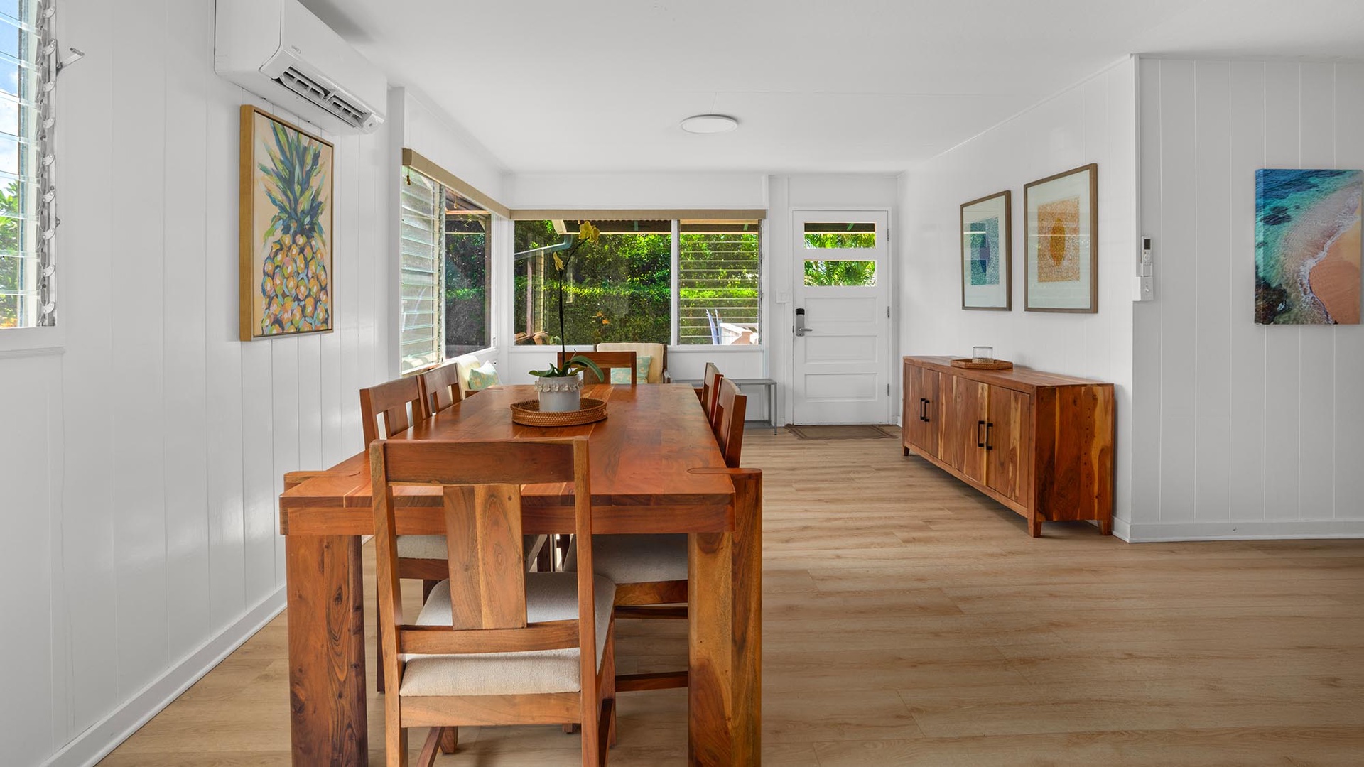 Gather around this warm wooden dining table with a view of lush greenery. The bright, airy space connects seamlessly to the outdoors, perfect for your morning coffee or shared meals.