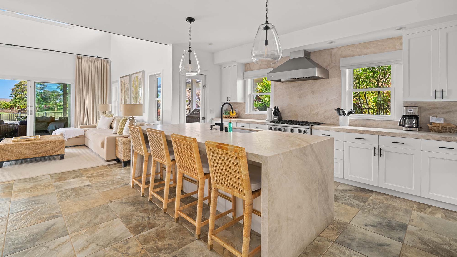 Step into your dream vacation home where an airy, sunlit kitchen flows seamlessly into a cozy living space. Imagine cooking meals on a chef-grade range, sipping coffee at the stylish stone island, and relaxing with views that bring the outdoors in.