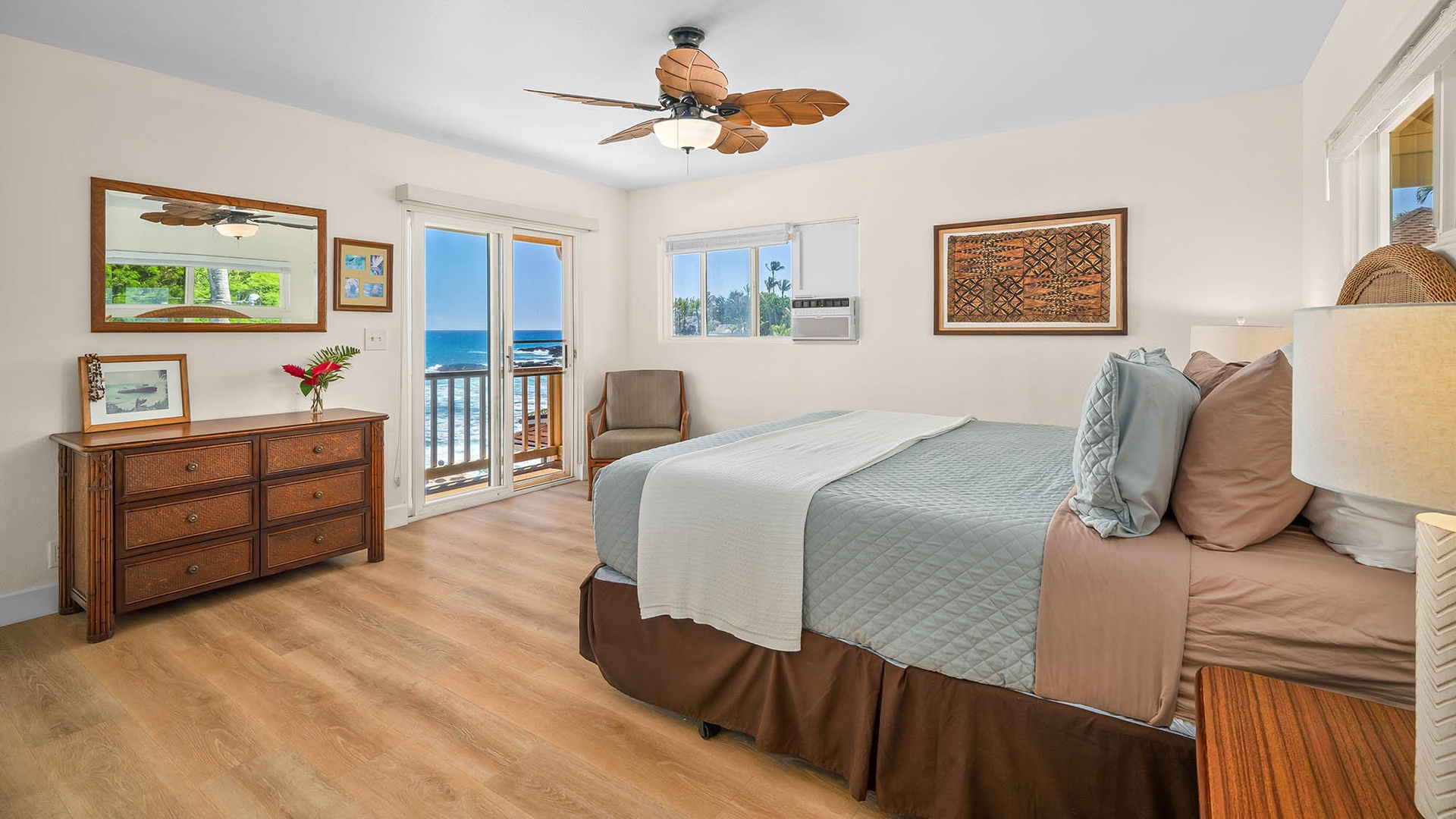Wake to ocean breezes and brilliant blue waters right outside your balcony doors. This serene bedroom invites relaxation with coastal-inspired decor and gentle ceiling fan, creating your perfect tropical retreat.