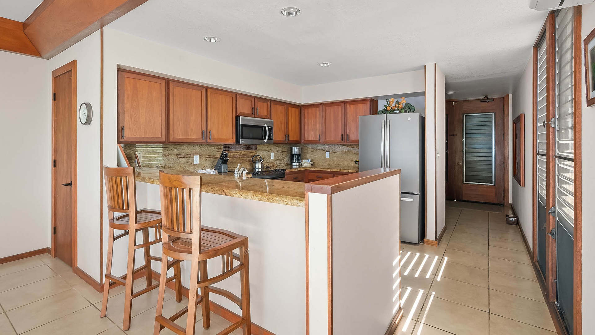 Whip up your favorite meals in this bright, fully equipped kitchen featuring granite countertops, stainless steel appliances, and a breakfast bar for casual dining.