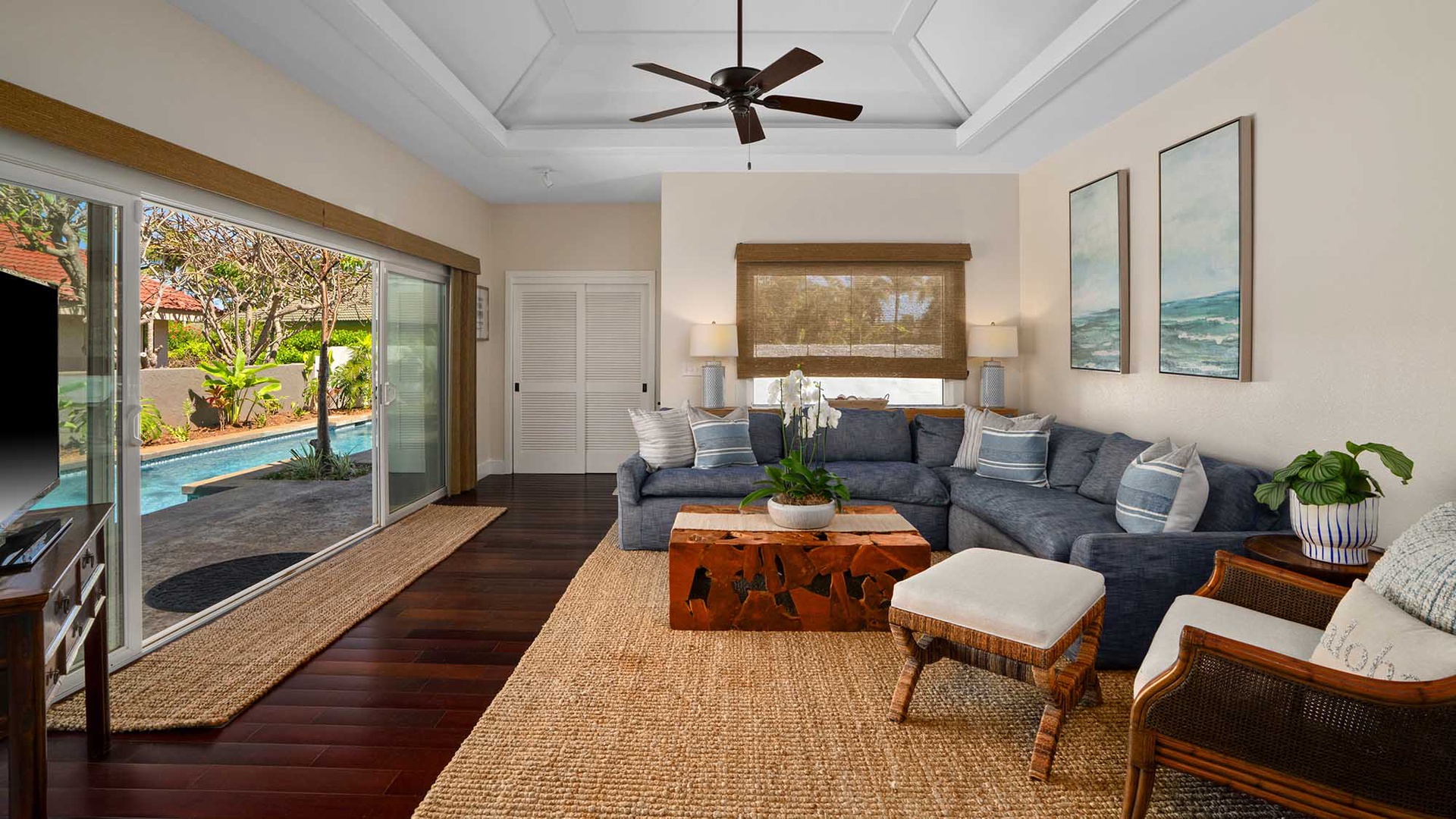 Sink into the deep cushions of this coastal living room, where natural textures and breezy décor create your perfect relaxation spot. Glass doors open to your private pool oasis just steps away.