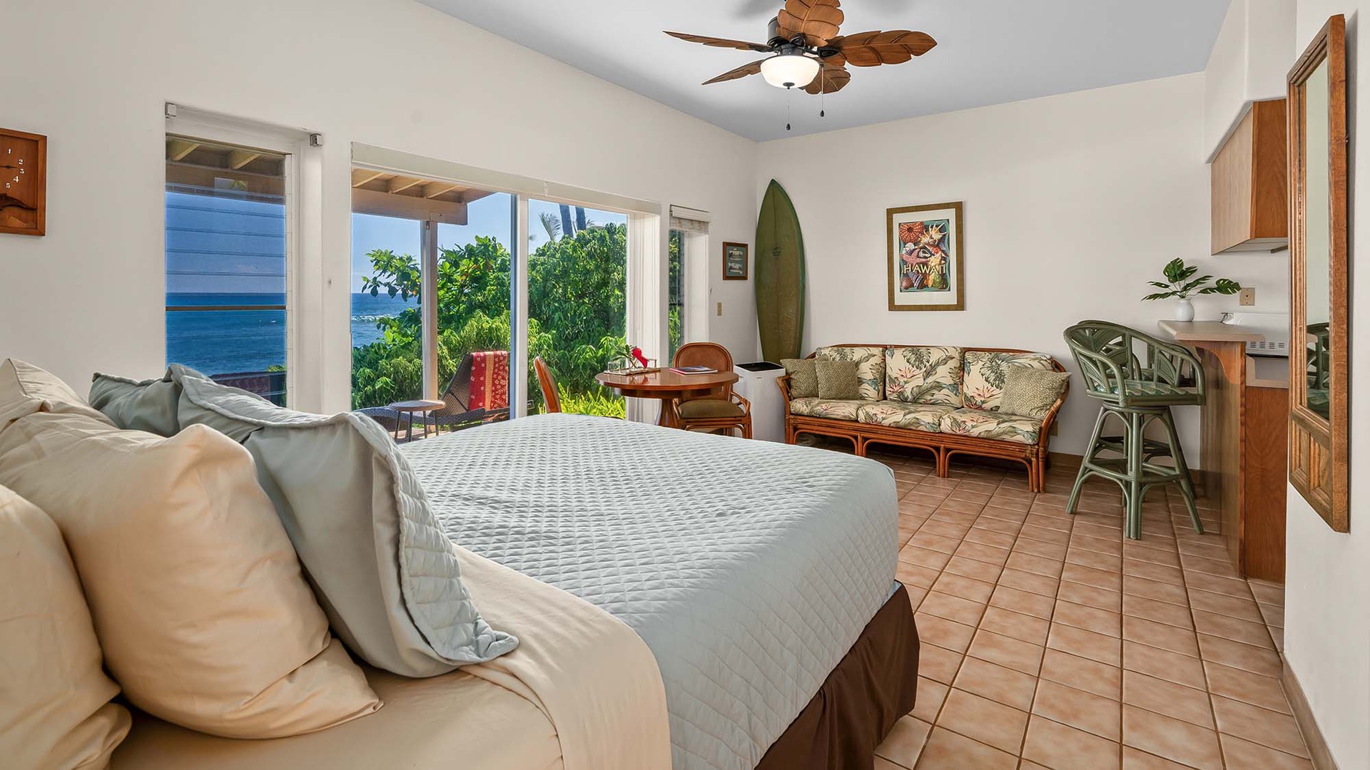 Wake up to breathtaking ocean views through your oversized glass doors, where tropical greenery frames the sparkling blue waters. Relax in your Hawaiian-inspired bedroom suite with island-style furnishings and direct access to the outdoor lanai.