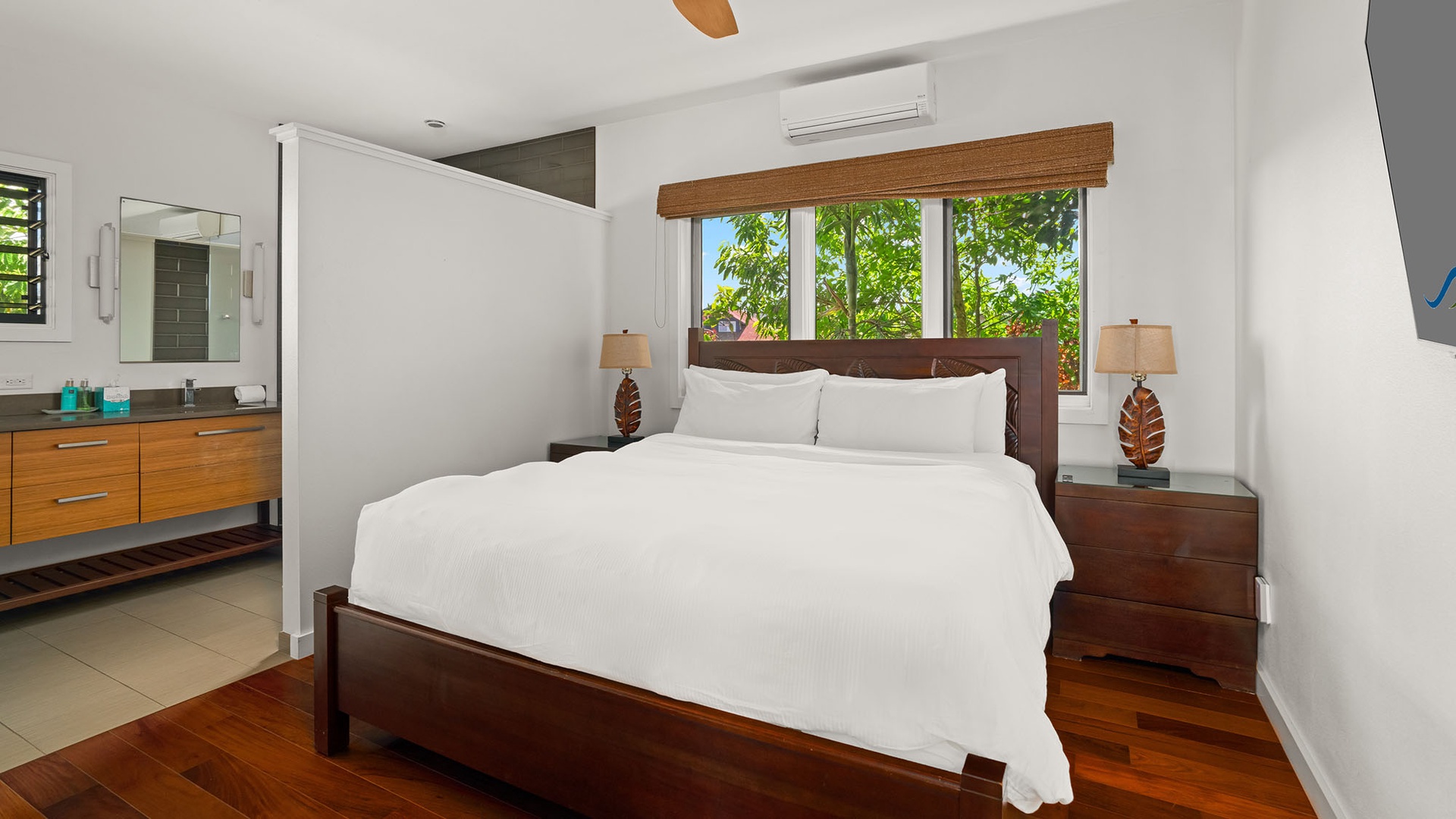 Sink into crisp white linens and wake to lush garden views framing your window. The sleek en-suite and tropical accents create your perfect retreat.