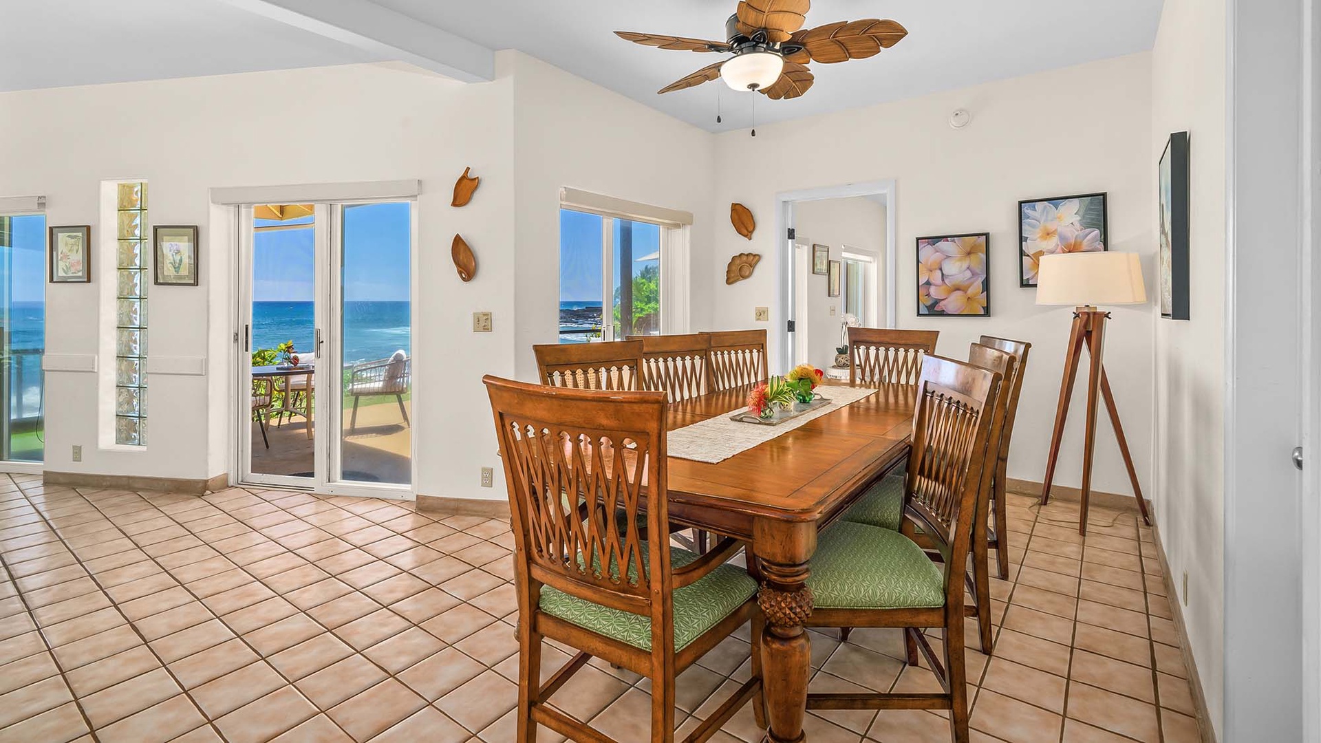 Gather around this inviting wooden dining table where you'll enjoy meals with stunning ocean views through French doors opening to your private terrace.