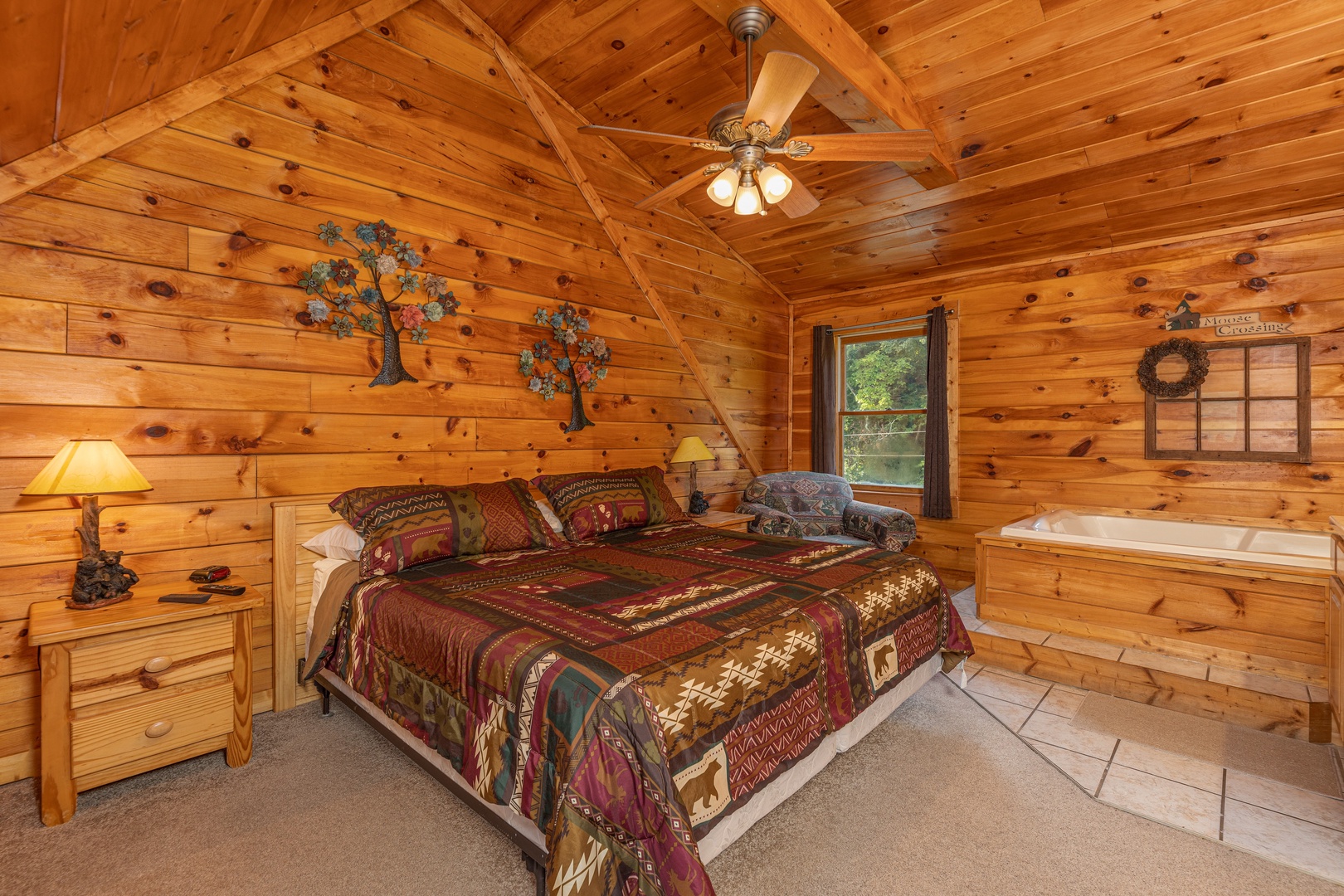 King bed, two night stands, two lamps, and a jacuzzi at Family Getaway, a 4 bedroom cabin rental located in Pigeon Forge