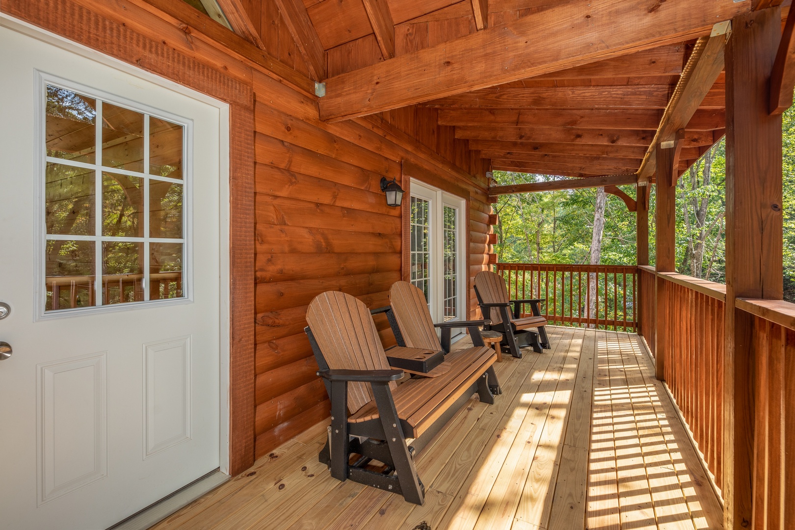 Adirondack chairs and bench on a deck at Gar Bear's Hideaway, a 3 bedroom cabin rental located in Pigeon Forge