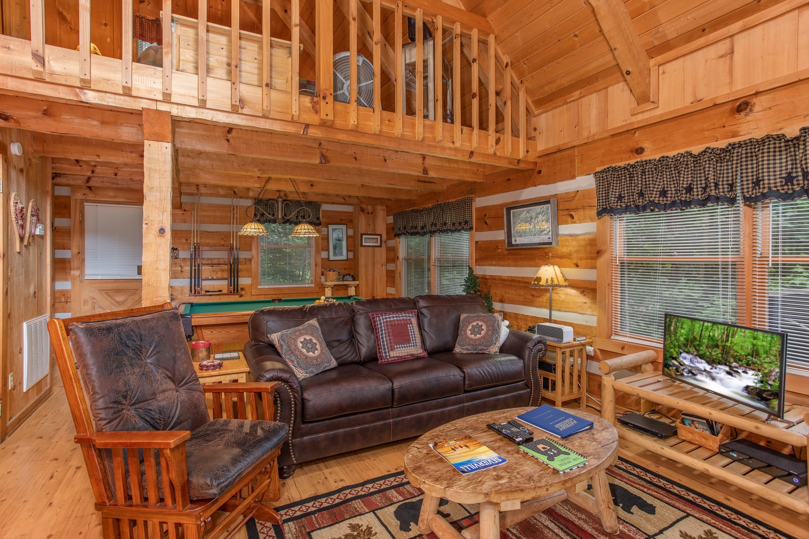 Sofa and a glider in the living room at Bearfoot Crossing, a 1-bedroom cabin rental located in Pigeon Forge
