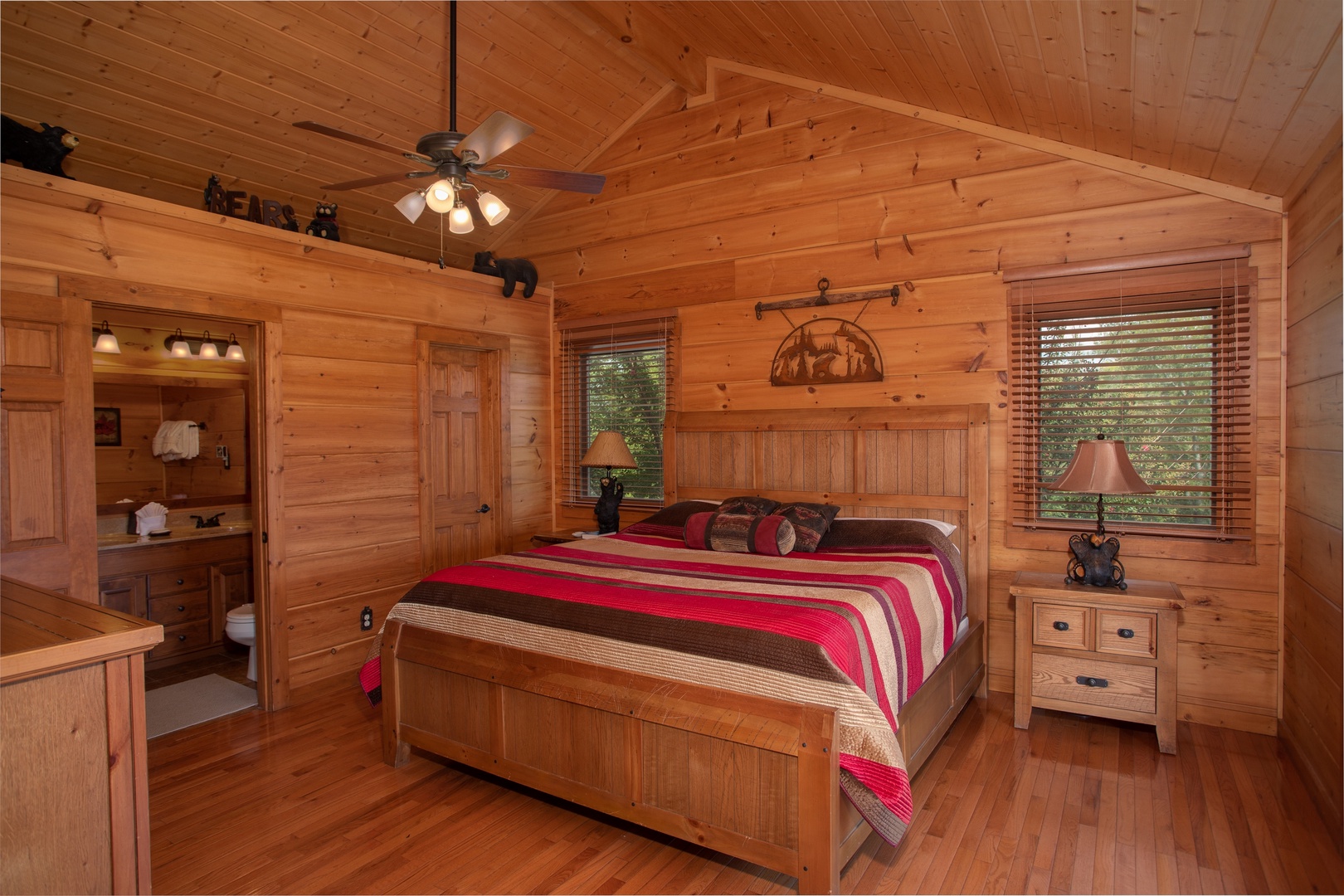 Bedroom with a king-sized wooden bed and vaulted ceilings at Cedar Creeks, a 2-bedroom cabin rental located near Douglas Lake