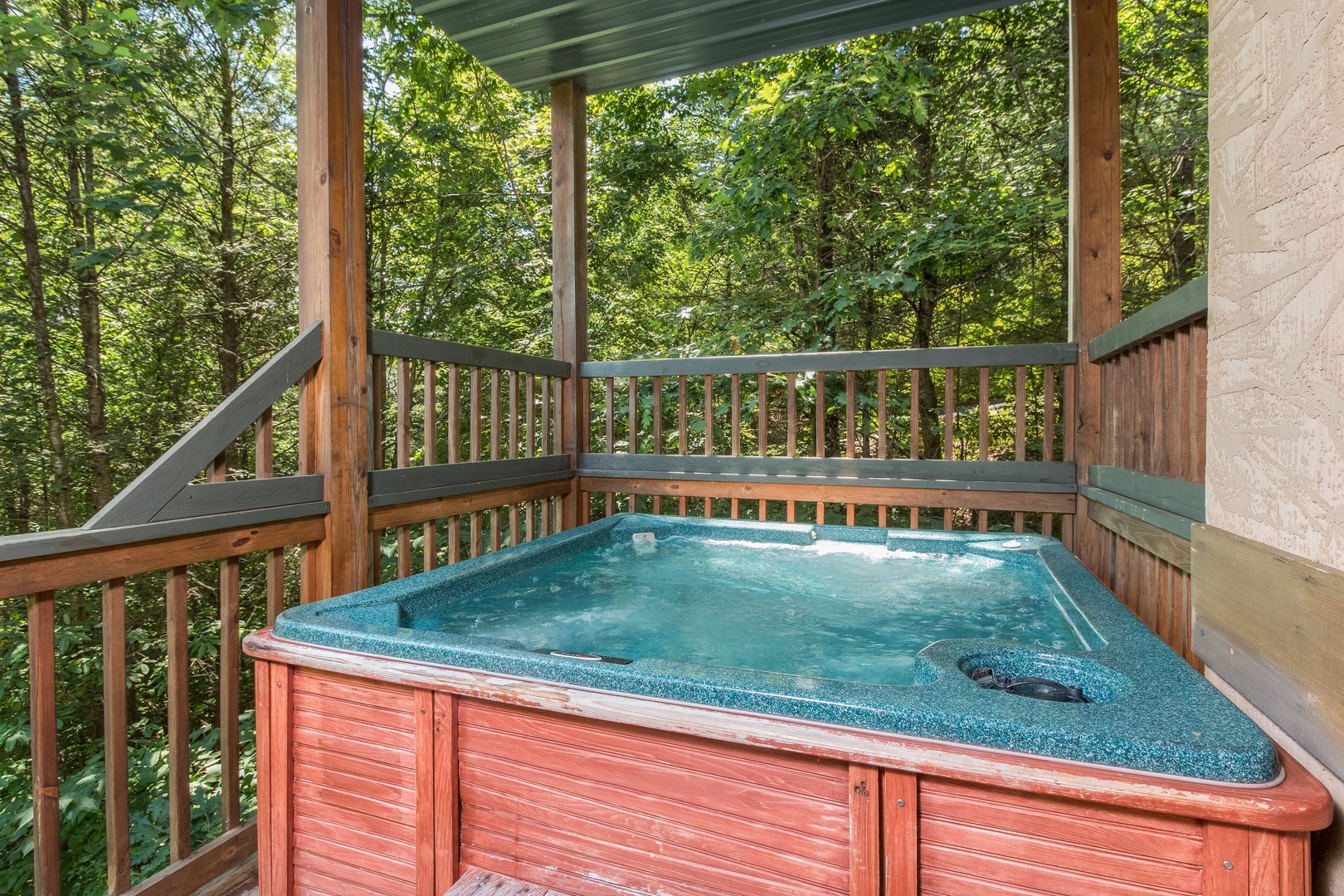 Hot tub on a covered deck at Stones Throw, a 4 bedroom cabin rental located in Pigeon Forge