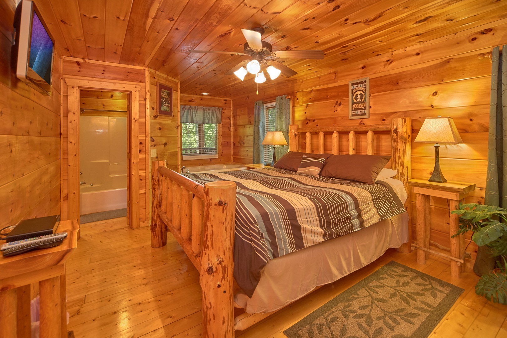 Bedroom with king bed, TV, and en suite bath at Love Struck, a 1 bedroom cabin rental located in Pigeon Forge