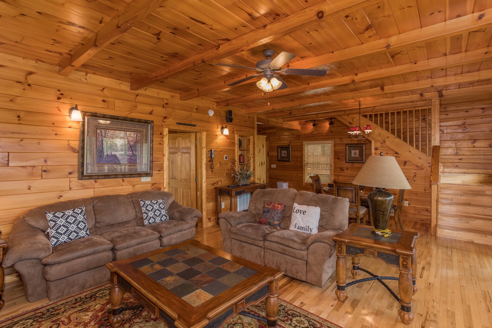 A sofa and loveseat in the living room at Howlin' in the Smokies, a 2 bedroom cabin rental located in Pigeon Forge