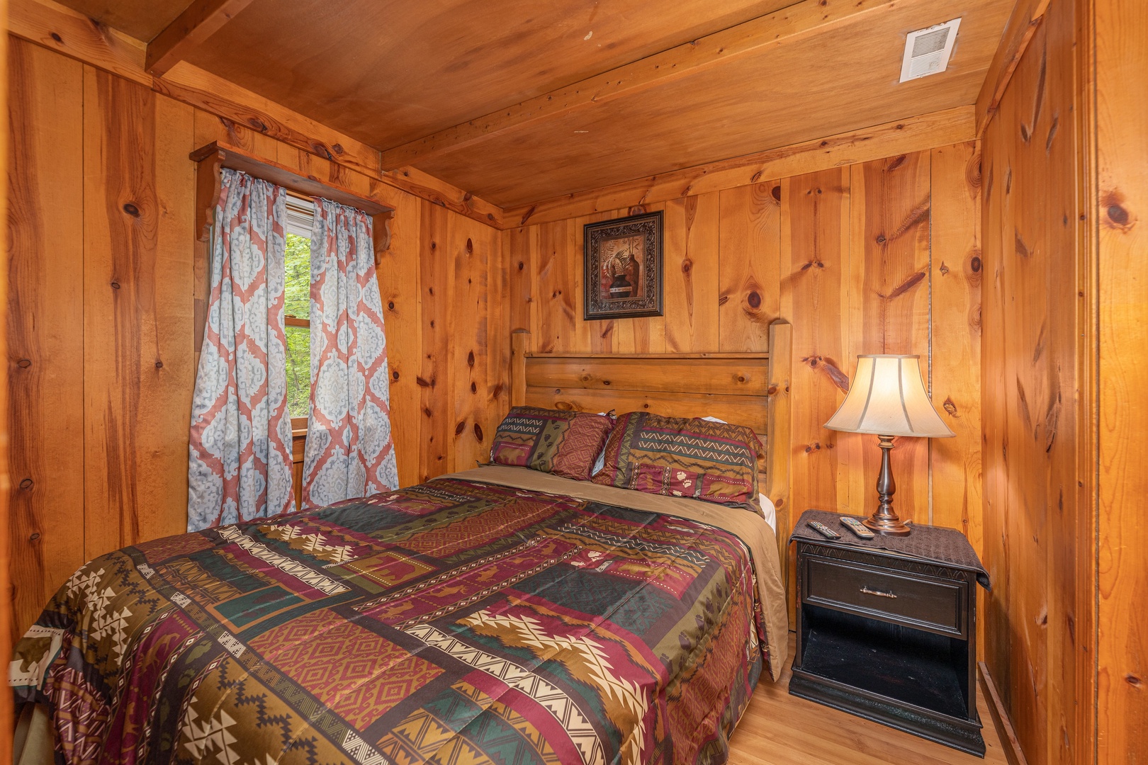 Bedroom with a night stand and a lamp at Heavenly Hideaway, a 2-bedroom cabin rental located in Gatlinburg