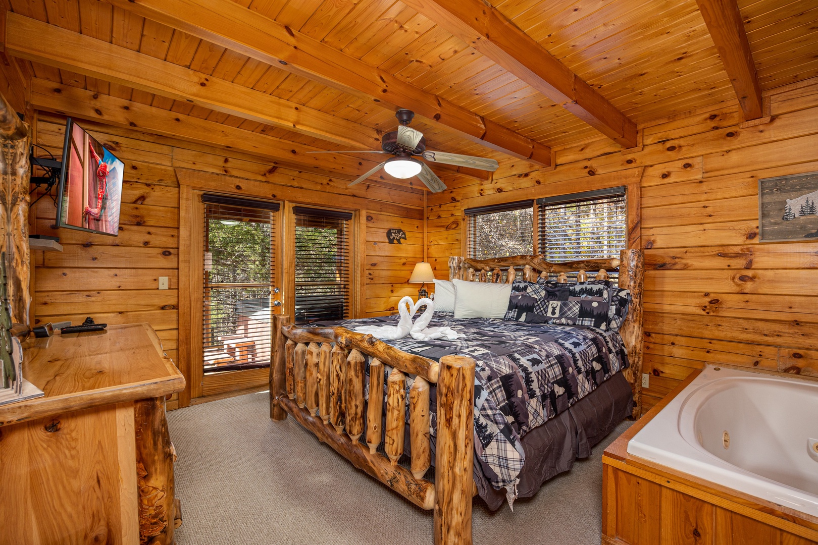 Log king bed and in room jacuzzi at Bear Feet Retreat, a 1 bedroom cabin rental located in pigeon forge