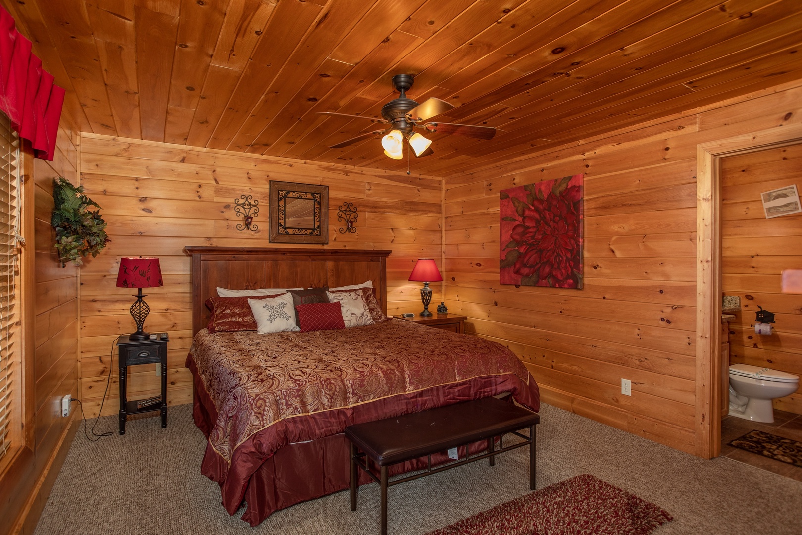 King bed with two night stands and en suite bath at Better View, a 4 bedroom cabin rental located in Pigeon Forge