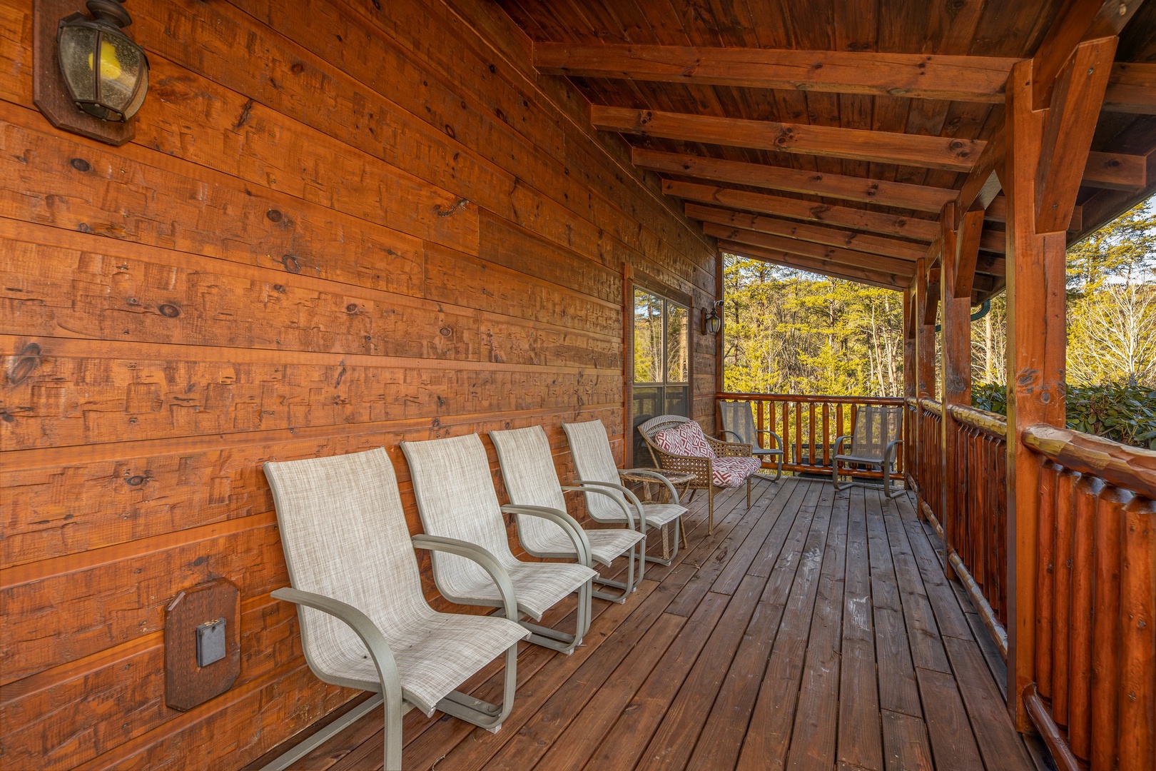 A covered deck with plenty of seating at King of the Mountain, a 3 bedroom cabin rental located in Pigeon Forge