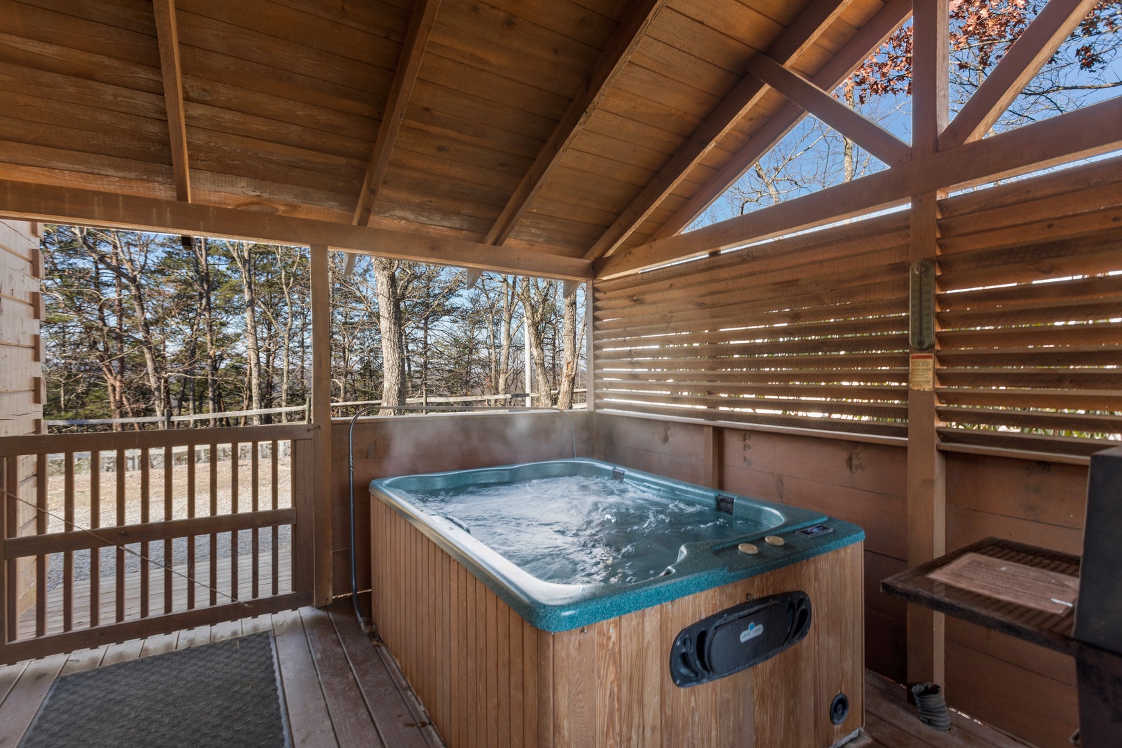 Hot tub on a covered deck at Mountain Magic, a 1 bedroom cabin rental located in Pigeon Forge