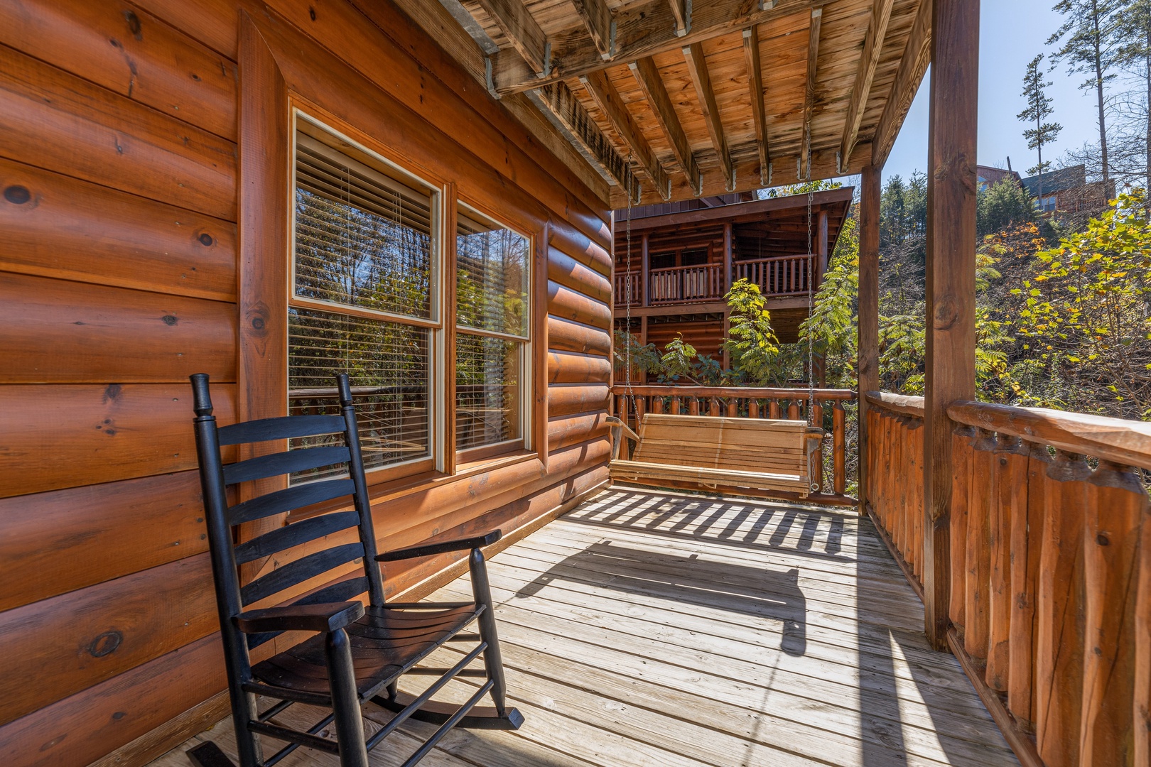 Porch swing and rocking chair on a deck at Bears Don't Bluff, a 3 bedroom cabin rental located in Pigeon Forge