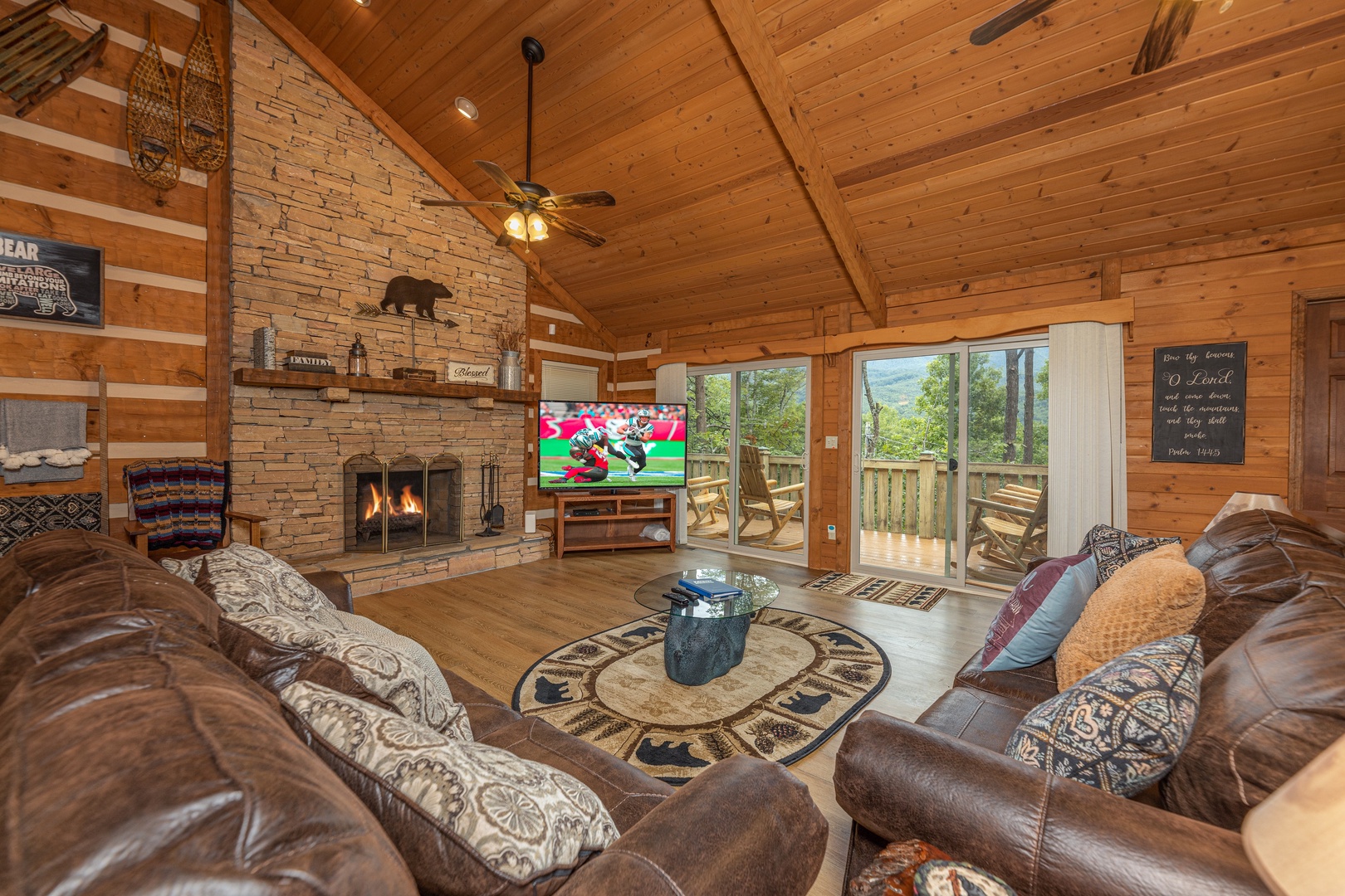 Living room with fireplace, TV, and deck access at Cubs' Crib, a 3 bedroom cabin rental located in Gatlinburg