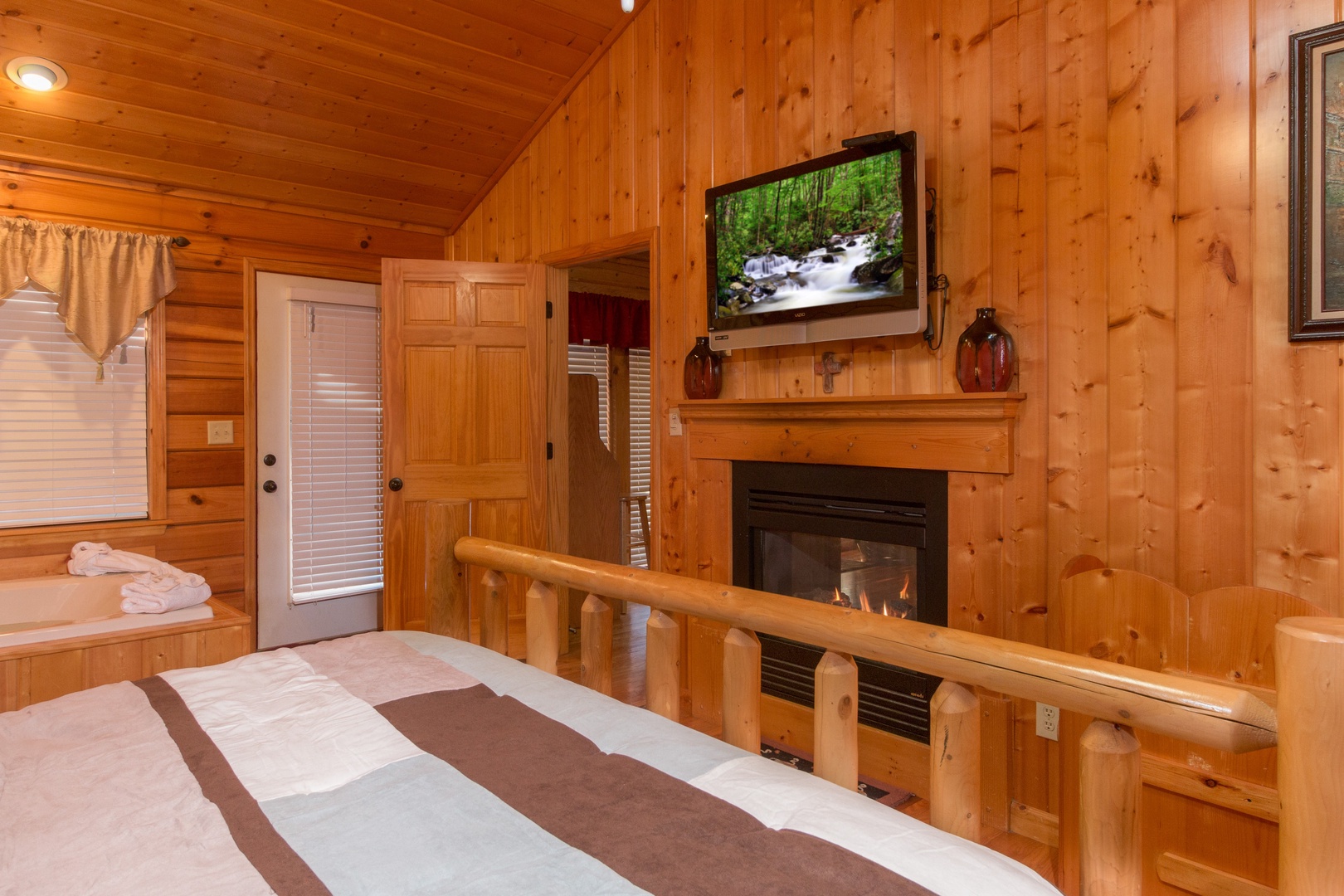 Fireplace and TV in a bedroom at A Beary Cozy Escape, a 1 bedroom cabin rental located in Pigeon Forge