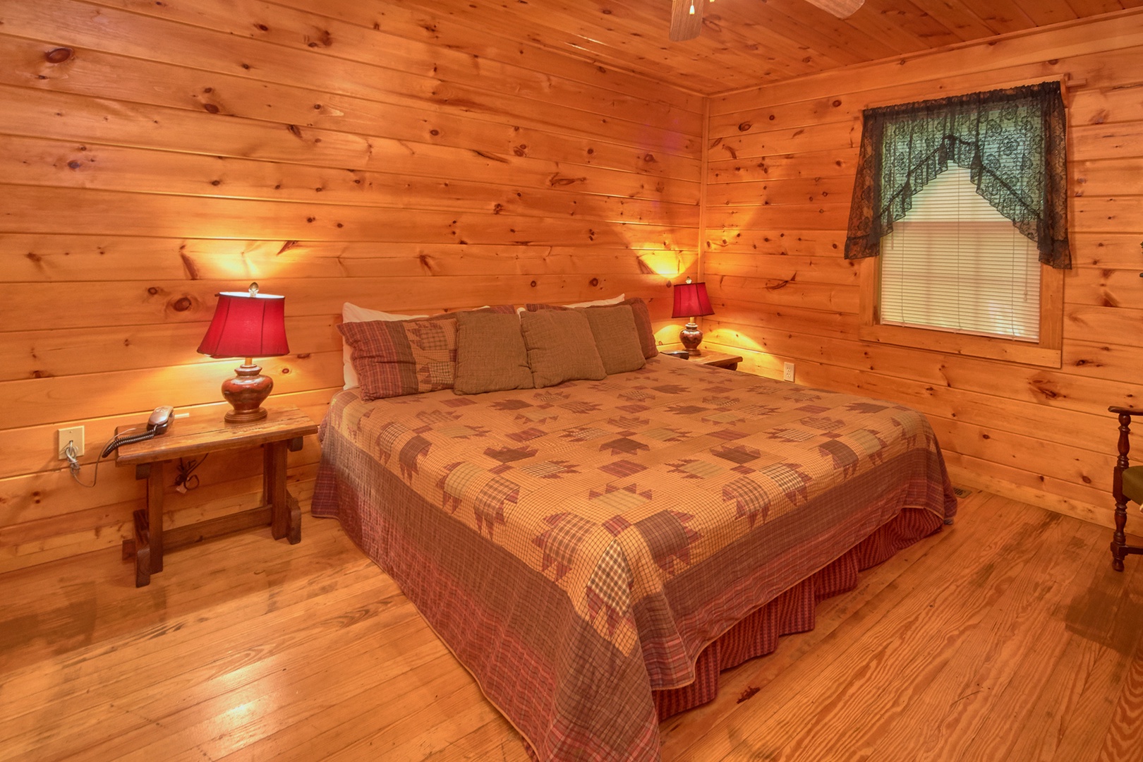 King-sized bed and two end tables at Dream Catcher, a 1-bedroom cabin rental located in Pigeon Forge