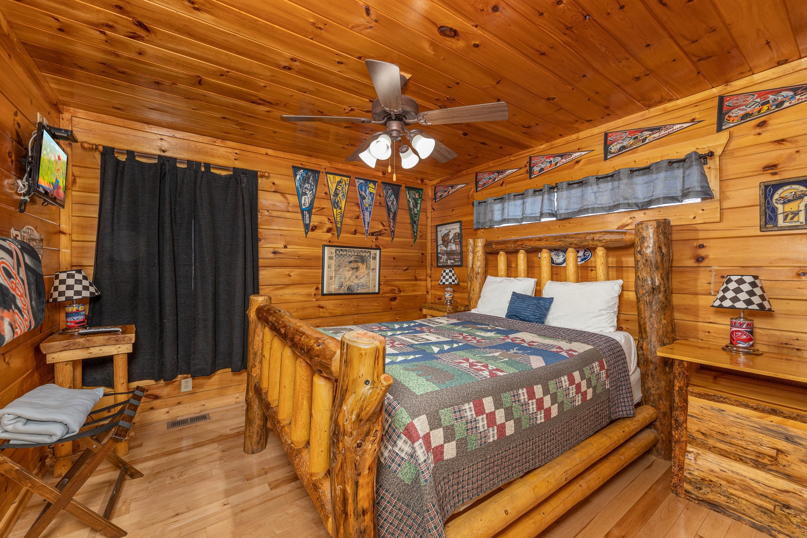 Bedroom with a log bed, dresser, and TV at Nascar Nation, a 2 bedroom cabin rental located in Pigeon Forge