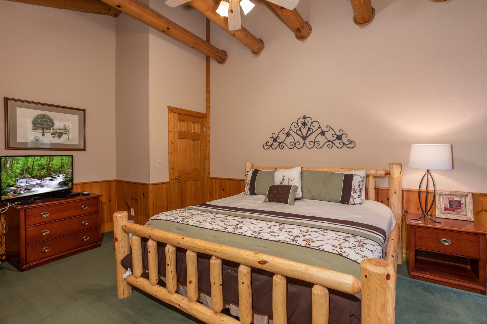 Bedroom with a king log bed, dresser, and TV at Starry Starry Night #725, a 2 bedroom cabin rental located in Pigeon Forge